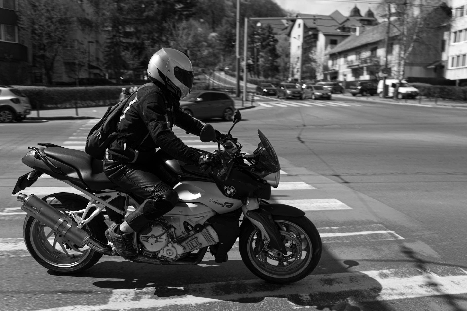 bike riding 桌布 壁紙 — 一名全副裝備的電單車手駕駛BMW R1200R穿過住宅區一個陽光普照的十字路口。