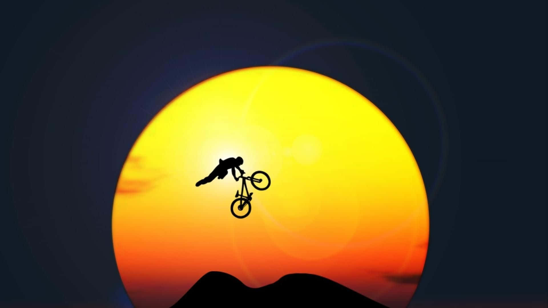 Mtb 桌布 壁紙 — 一名單車手在山脈剪影上方巨大發光的日落背景下表演大膽的空中特技。
