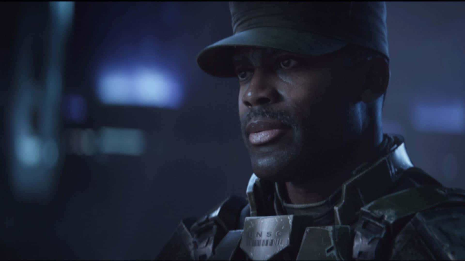 Sergeant Johnson 桌布 壁紙 — 一名嚴肅士兵身穿深色軍裝和帽子，在昏暗藍色燈光下的特寫。
