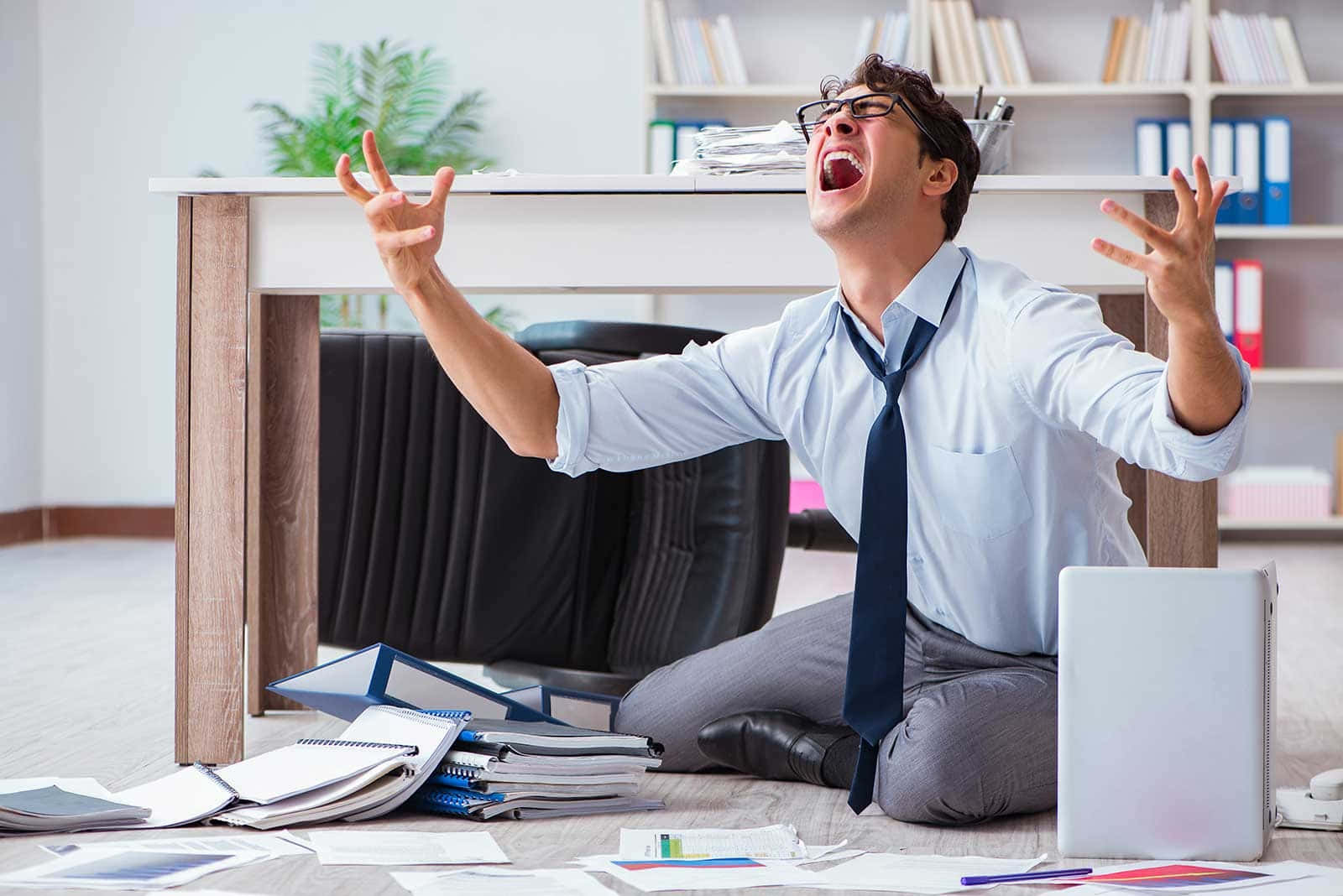 Emotions 桌布 壁紙 — 一名壓力大的商人坐在地上，被散落的文件和辦公室雜物包圍，沮喪地尖叫。