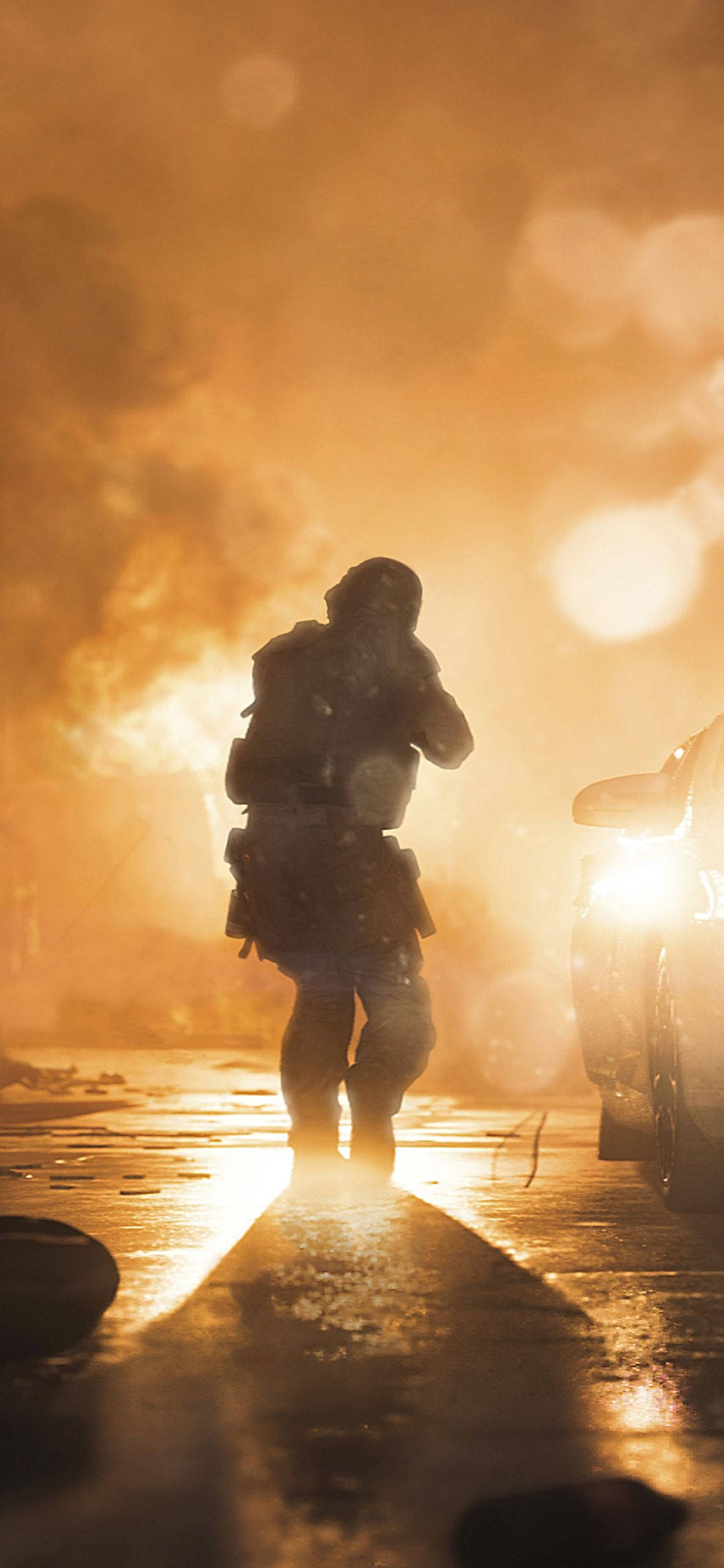 Call Of Duty Modern Warfare iPhone 桌布 壁紙 — 一名士兵剪影在夜間穿過燃燒的城市街道，車頭燈穿透煙霧。