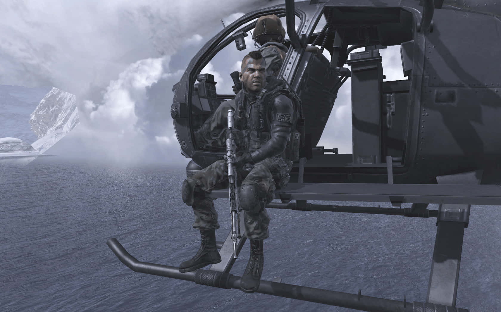 Soap Mactavish 桌布 壁紙 — 一名士兵坐在軍用直升機的滑橇上，直升機在波濤洶湧的海洋上空盤旋，遠處是白雪覆蓋的山脈。