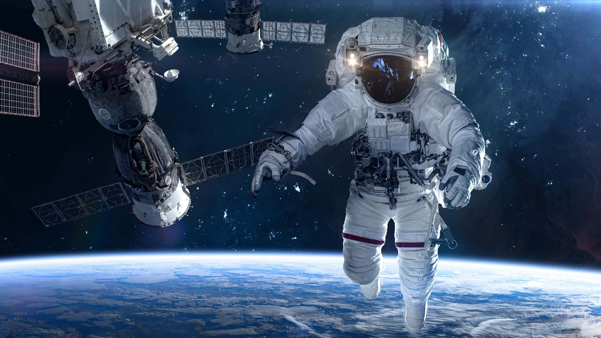 Live Space 桌布 壁紙 — 一名太空人在國際太空站外零重力漂浮，背後是地球的藍色曲線和星空。