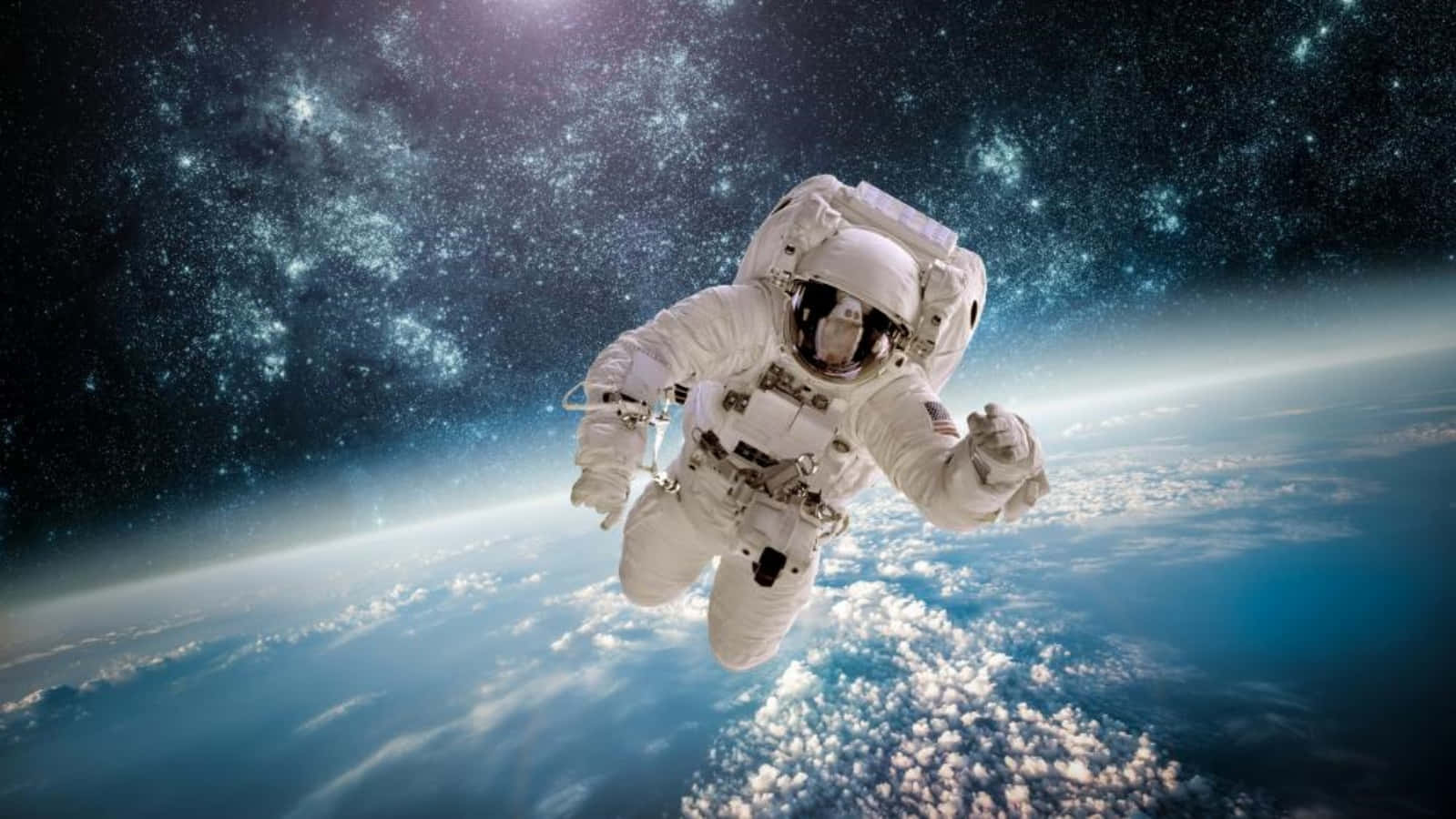 Space Exploration 桌布 壁紙 — 一名太空人在地球藍色雲層覆蓋的表面上方失重漂浮，背景是繁星點點的宇宙。