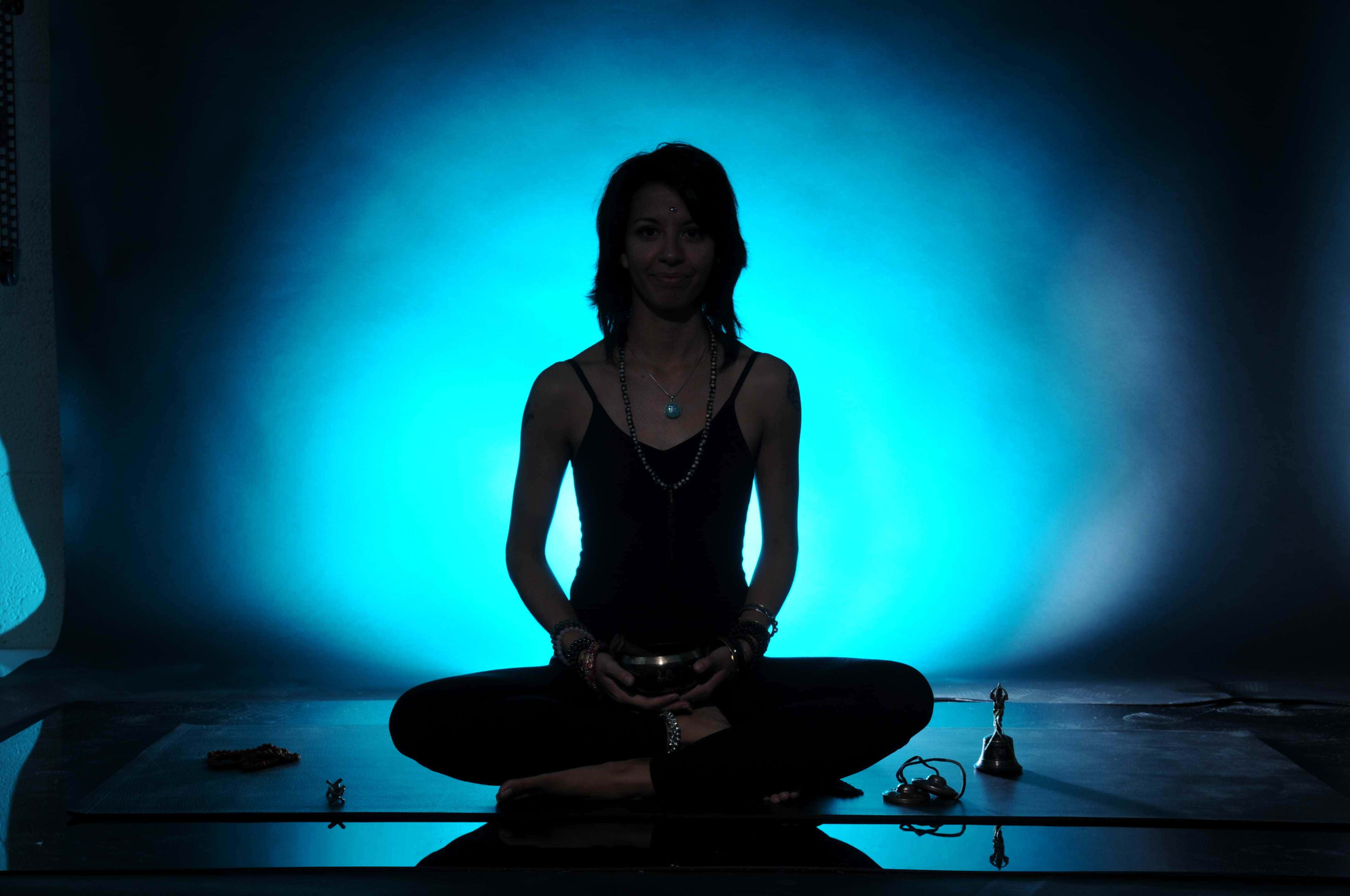 Spiritual Meditation 桌布 壁紙 — 一名女性盤腿而坐，在發光的藍色背景下形成冥想剪影，手持一個碗。
