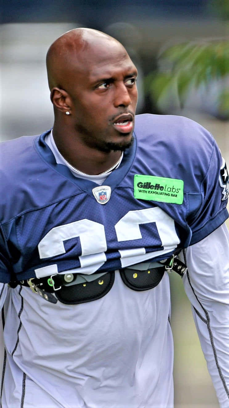 Devin Mccourty 桌布 壁紙 — 一名專注的足球運動員身穿藍色球衣，號碼24，帶有Gillette Labs標誌，專注地看向鏡頭外。