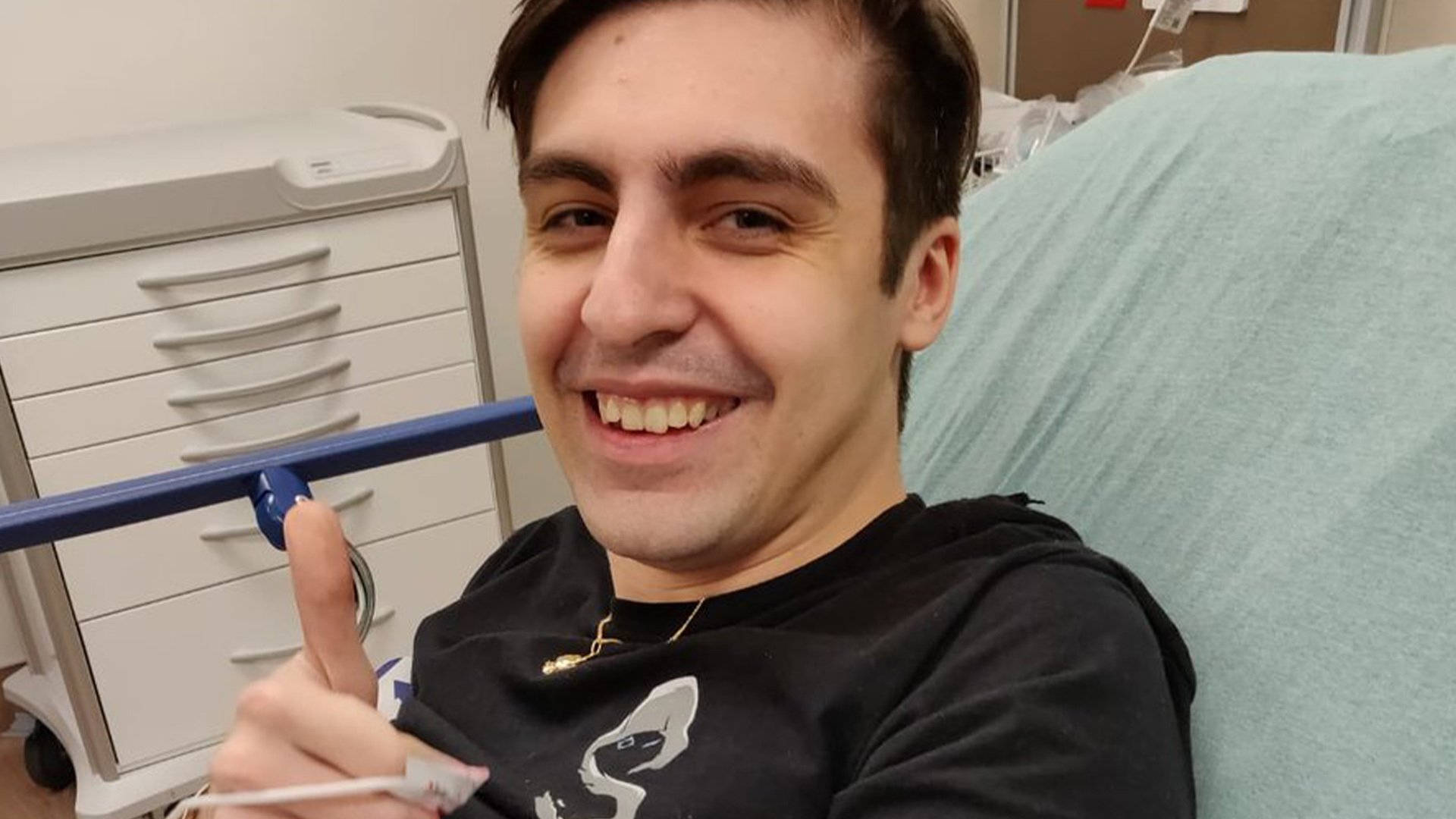 Goofy Player Shroud 壁紙 — 一名微笑的男子在醫院床上豎起大拇指，同時拿著溫度計。