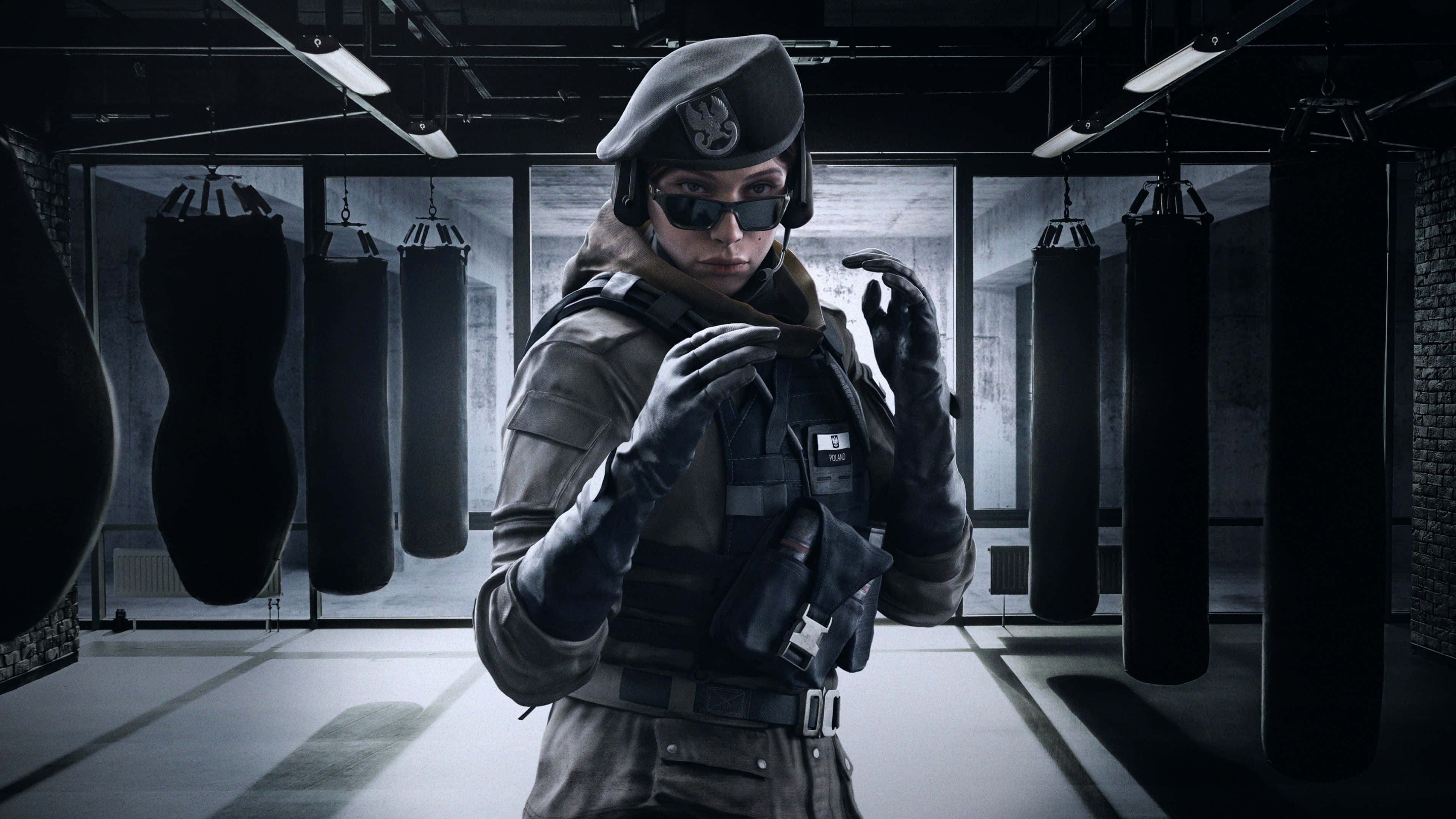 Zofia R6 桌布 壁紙 — 一名戰術士兵在光線昏暗的健身房中，被懸掛的沙袋包圍，調整裝備。