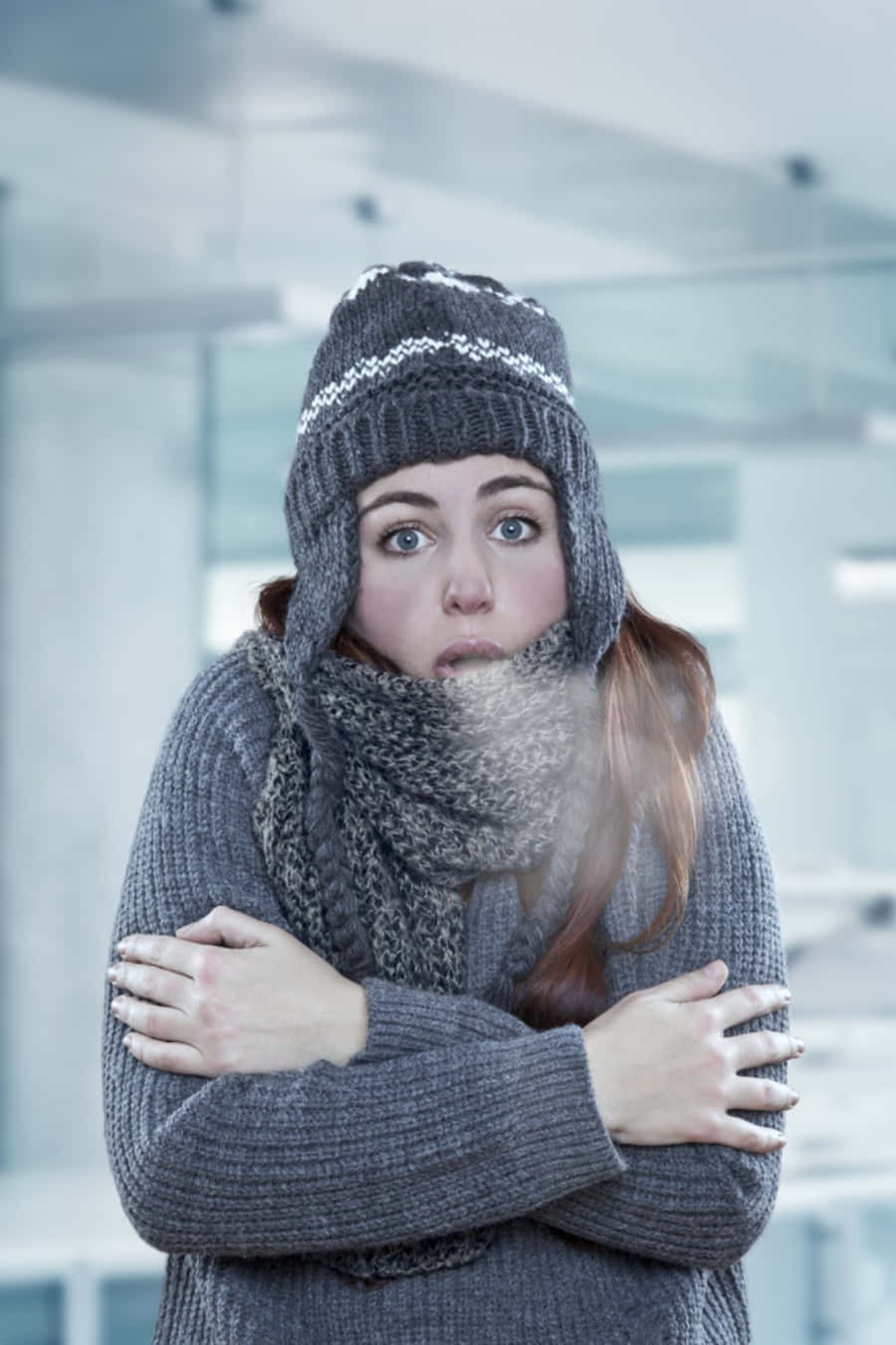 寒冷 桌布 壁紙 — 一名戴著灰色針織帽和圍巾的女性在涼爽的室內環境中顫抖，呼出的氣息清晰可見。