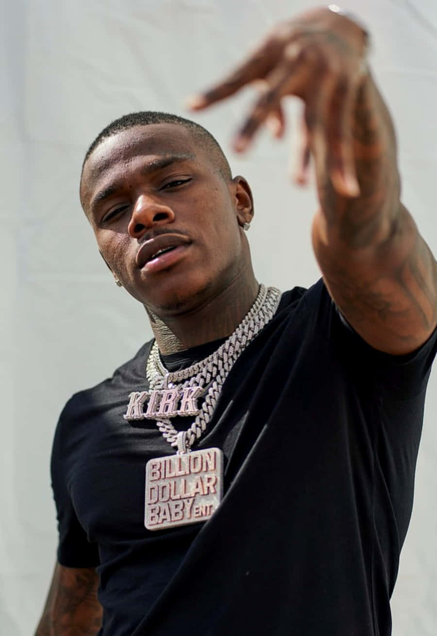 Dababy 桌布 壁紙 — 一名有紋身和戴著粗鏈條項鍊的男子在純白色背景前自信地擺姿勢。