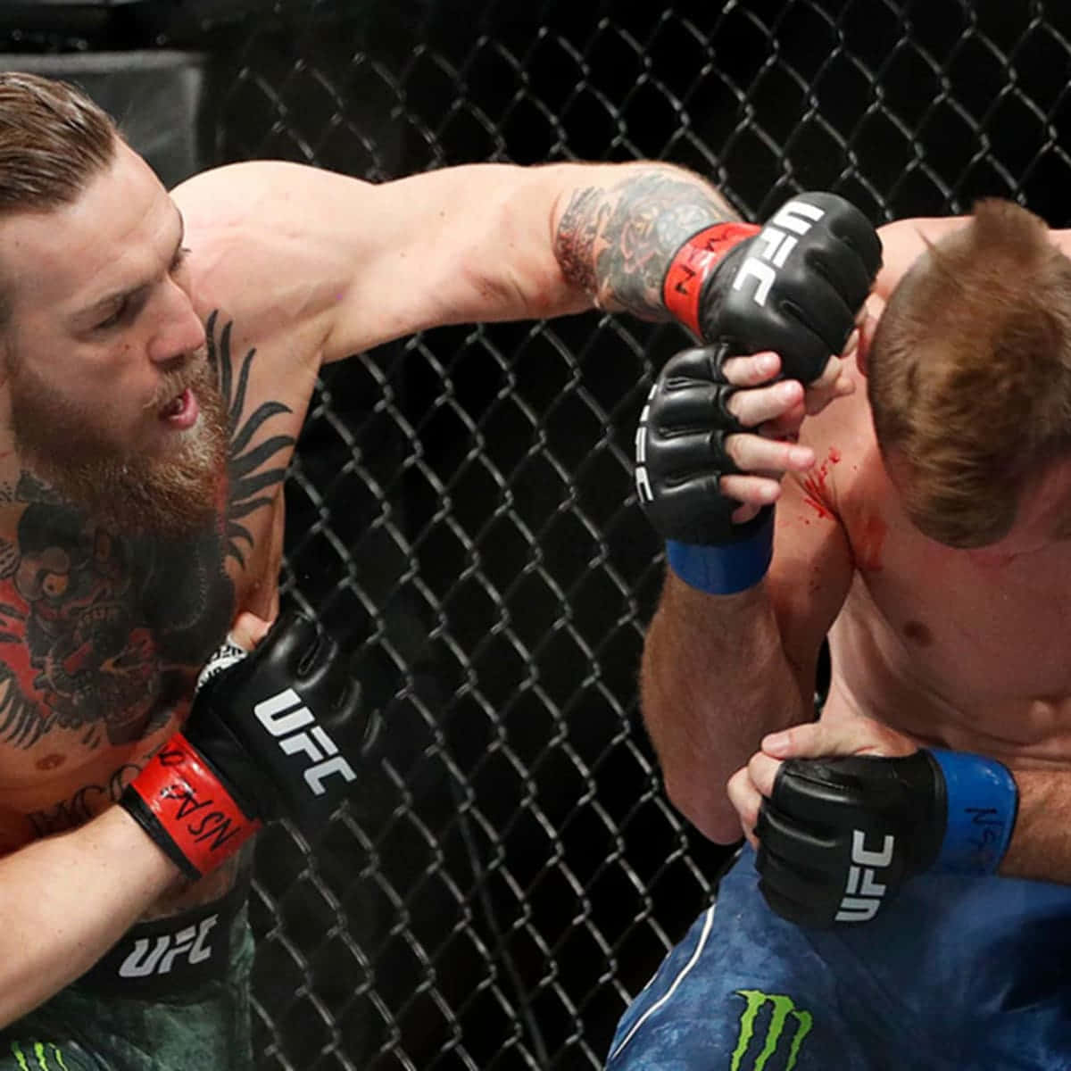 UFC 桌布 壁紙 — 一名有紋身的拳手在UFC八角籠內向對手面部猛烈出拳。
