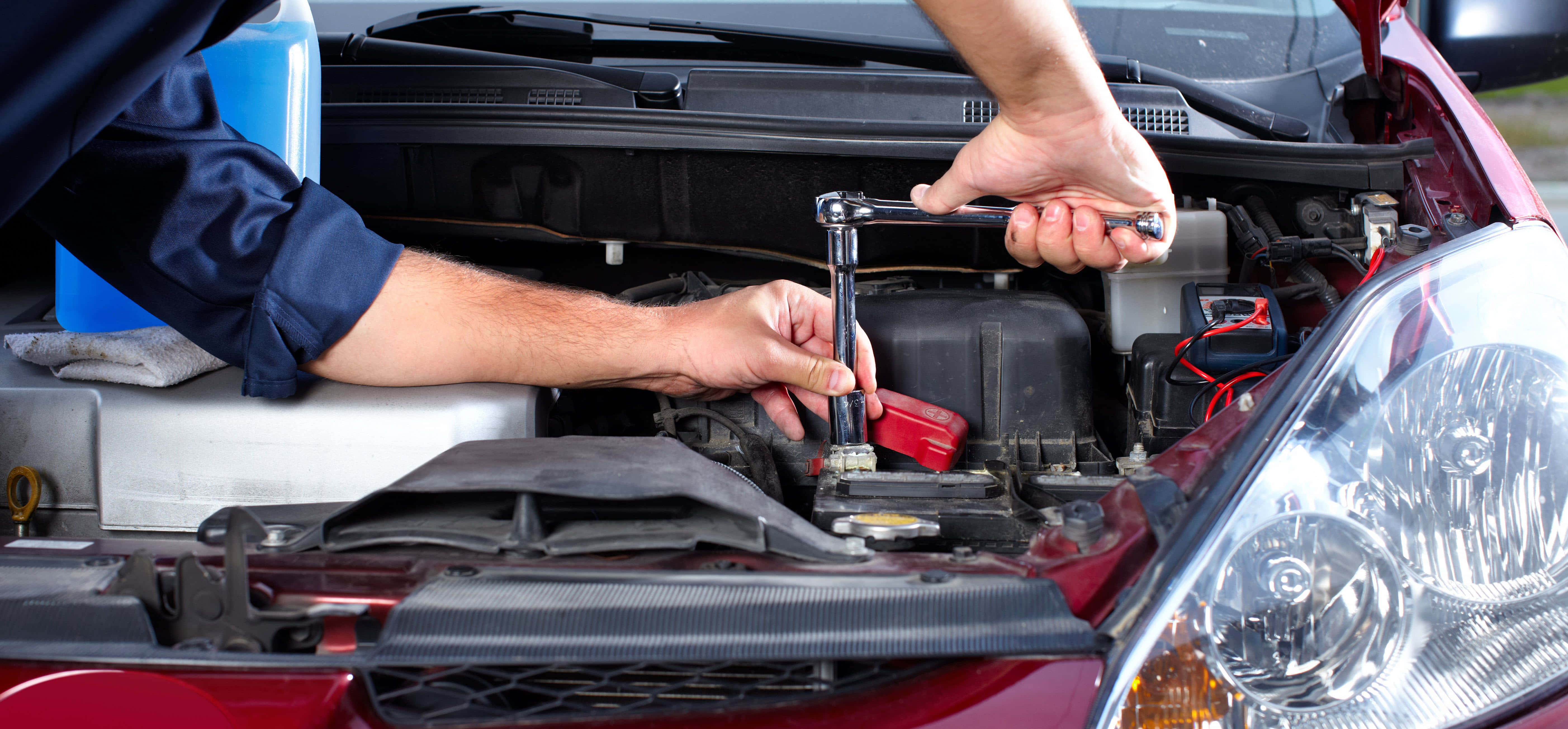 Car Repair 桌布 壁紙 — 一名機械師使用扳手在紅色汽車的引擎蓋下擰緊螺栓，工具和液體清晰可見。