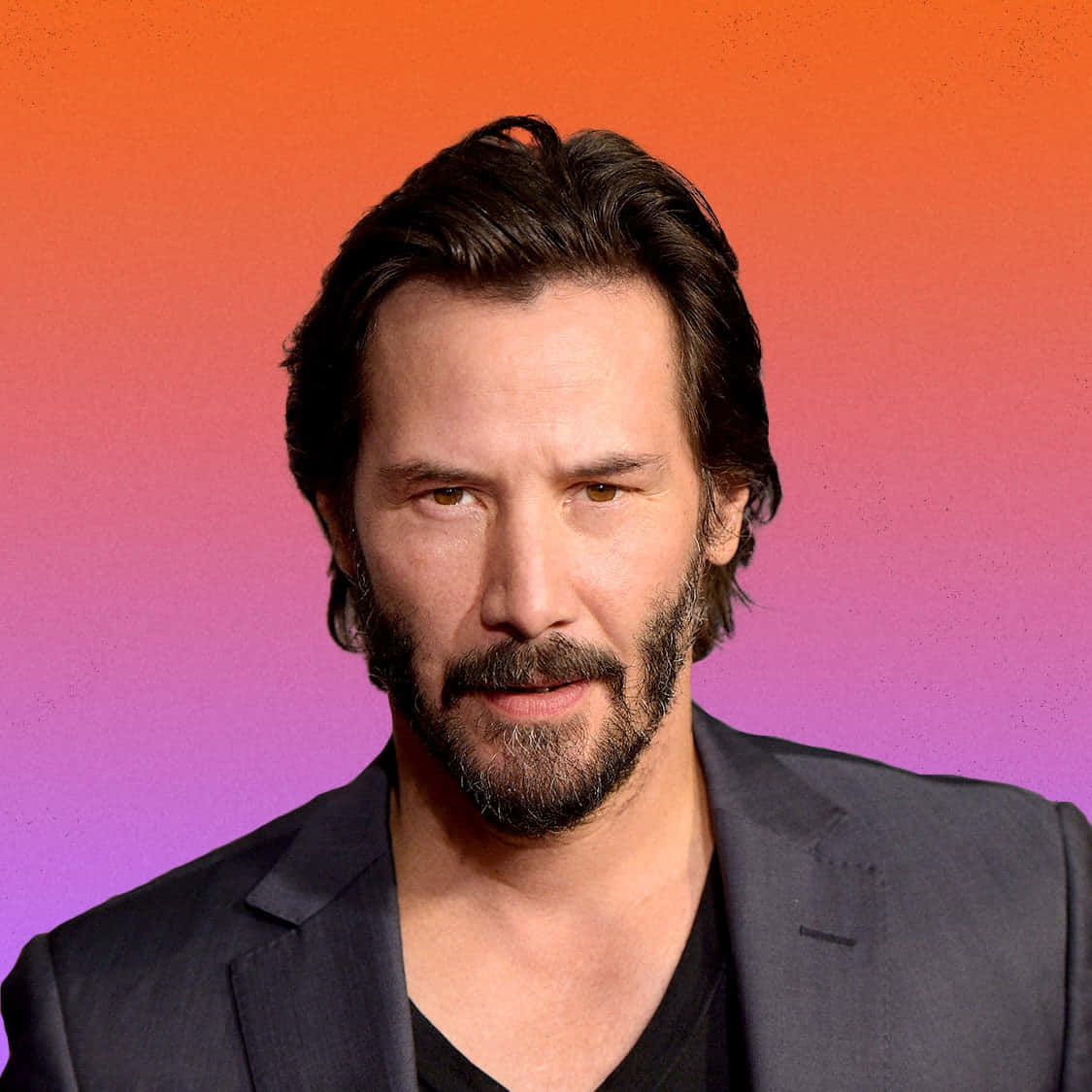 Keanu Reeves 桌布 壁紙 — 一名深色頭髮和鬍鬚的男子，身穿深色西裝，背景是充滿活力的橙色到紫色漸變色。