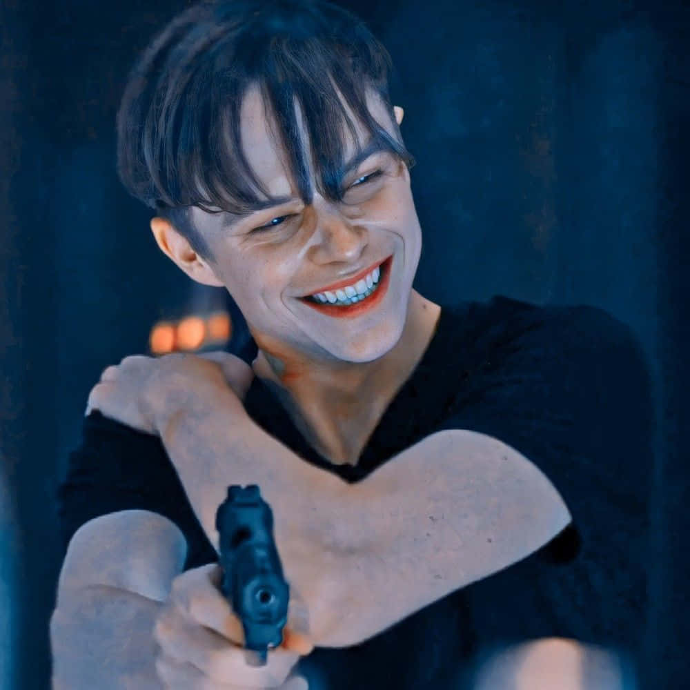 Harry Osborn 桌布 壁紙 — 一名深色頭髮的男子在昏暗的藍色房間裡握著手槍，狂笑著。