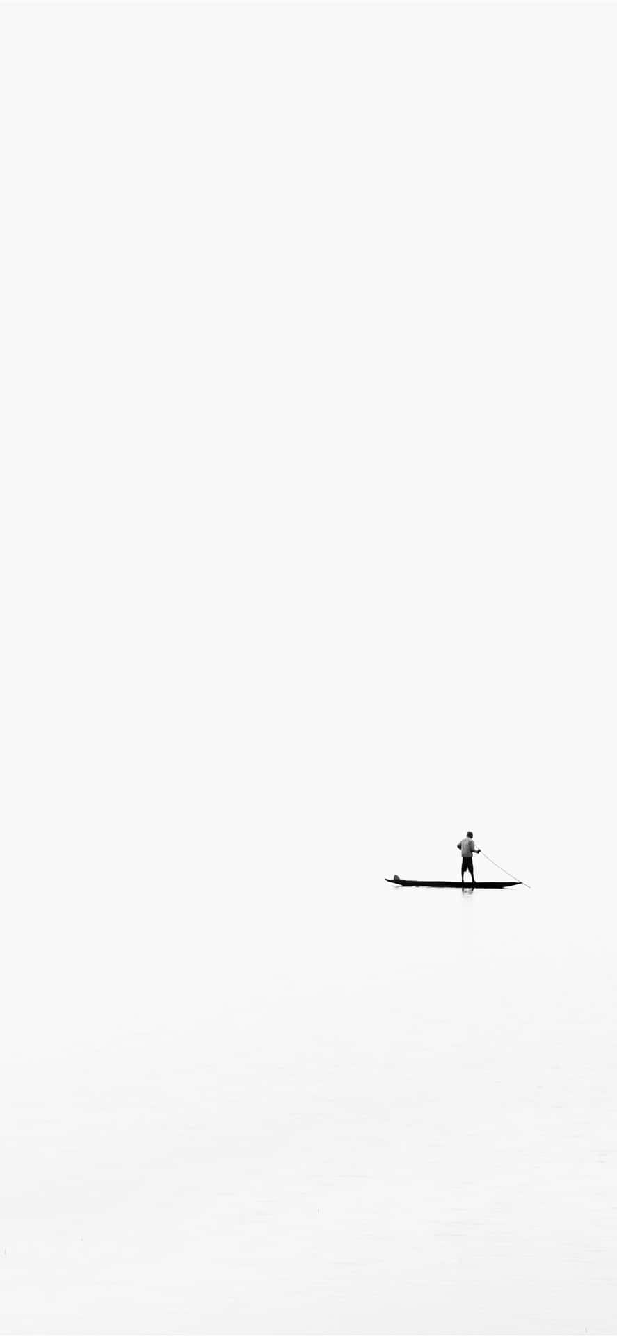 Minimalist Black And White 桌布 壁紙 — 一名獨自划槳板的人在一片廣闊、霧濛濛的白色水面上滑行，天空多雲。