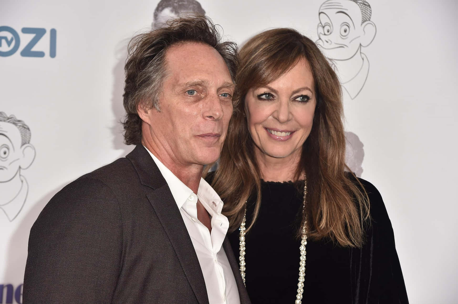 William Fichtner 桌布 壁紙 — 一名男子和一名女子在一個Mozi活動中一起擺姿勢，背景有卡通角色草圖。