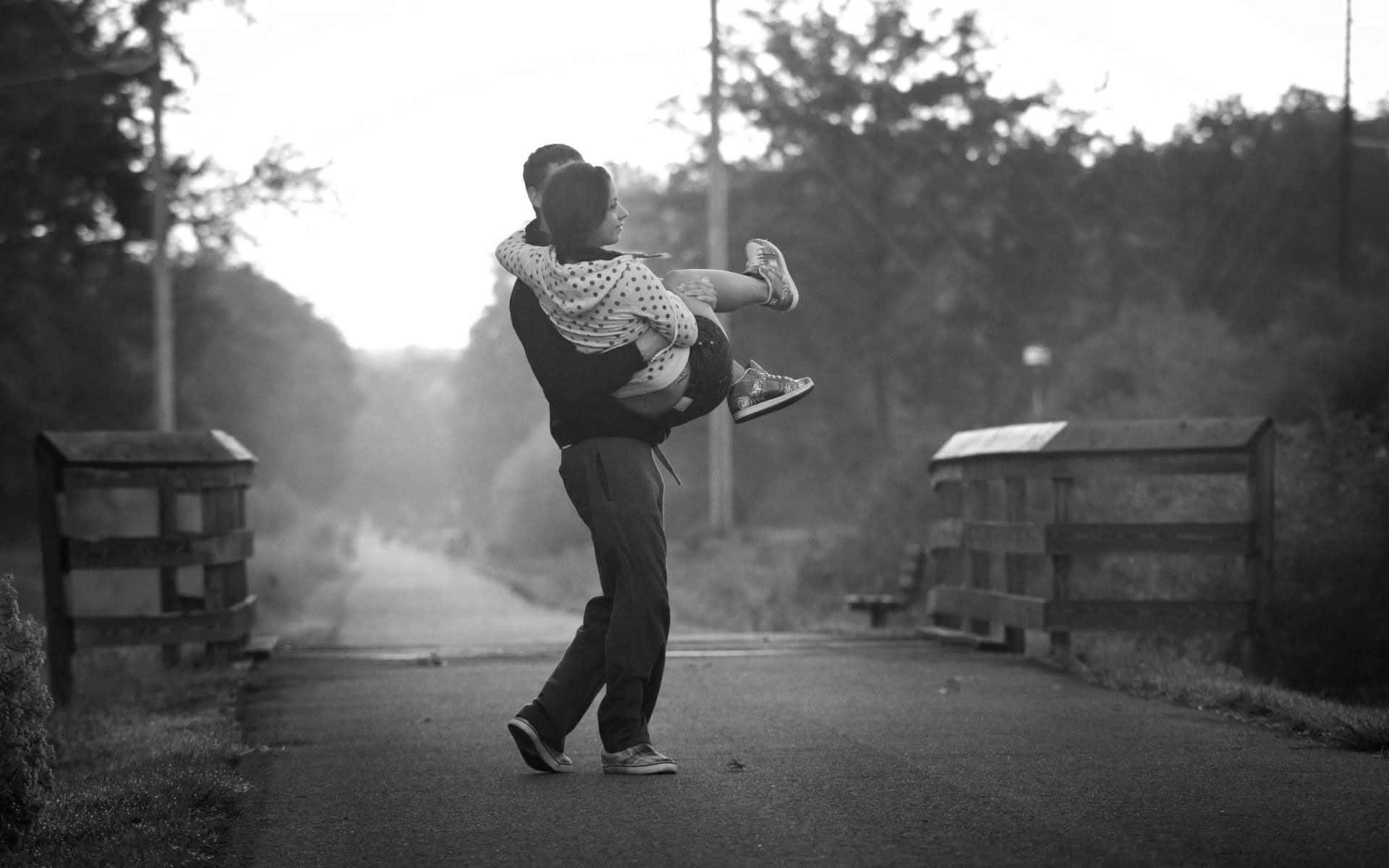 Lovers 桌布 壁紙 — 一名男子在霧氣瀰漫的鄉村道路上，兩旁有木柵欄和樹木，高興地將孩子舉到空中。