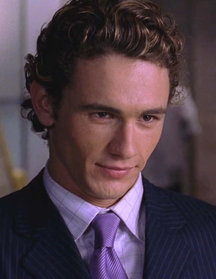 Harry Osborn 桌布 壁紙 — 一名留著棕色捲髮、身穿細條紋西裝及紫色領帶的男士特寫。