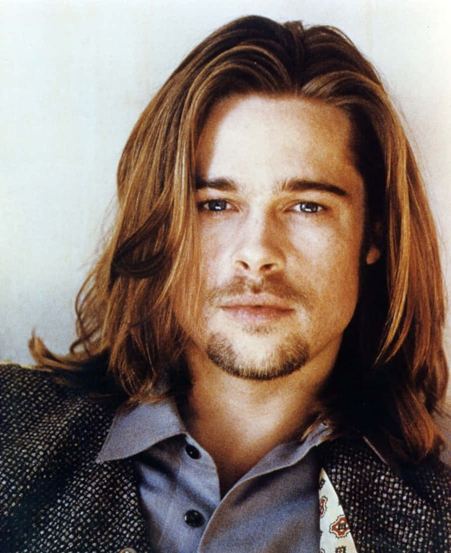 Brad Pitt 桌布 壁紙 — 一名留著長波浪棕色頭髮和淺鬍鬚的男子，身穿有領襯衫外搭圖案外套的特寫肖像。