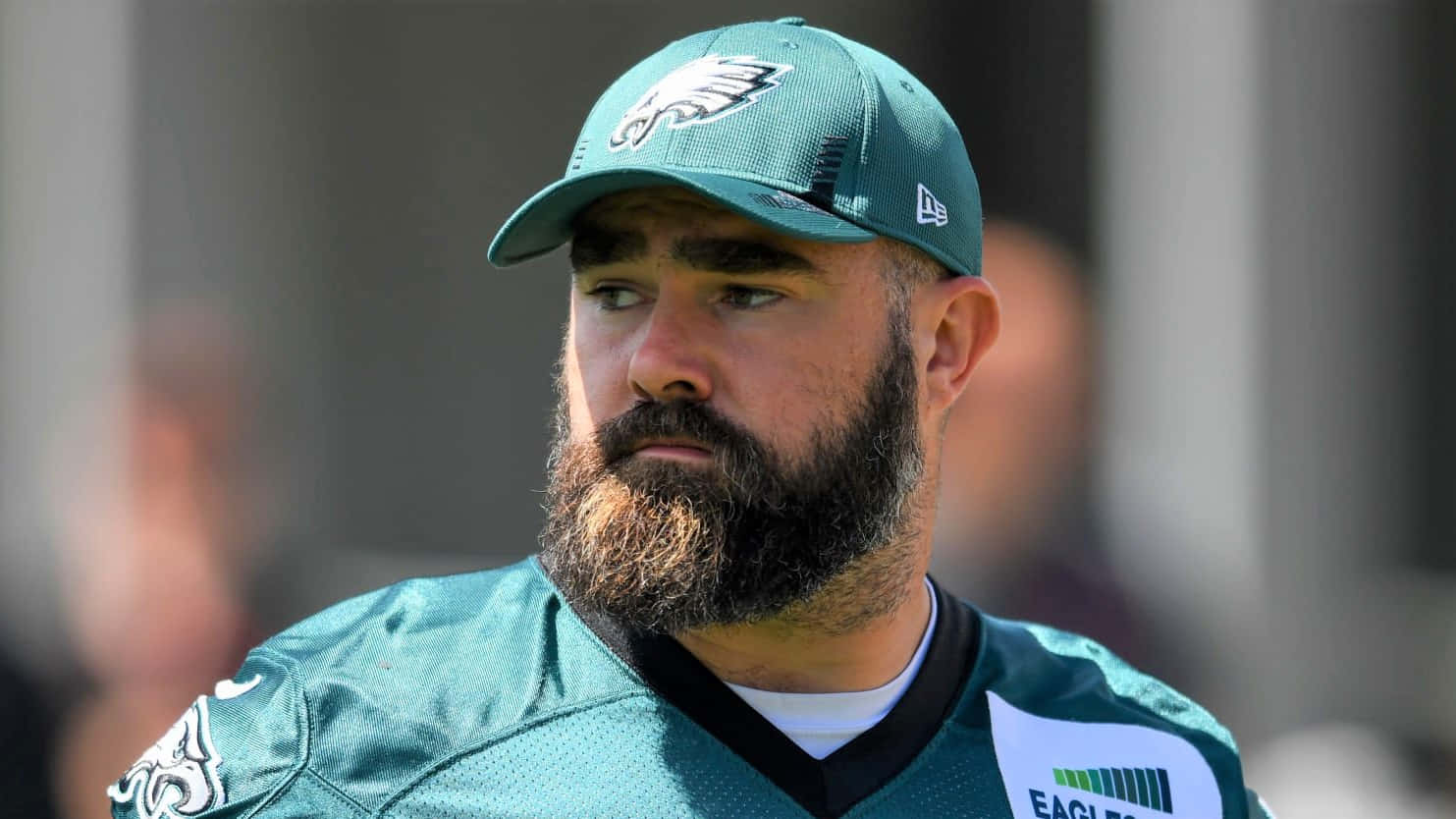 Jason Kelce 桌布 壁紙 — 一名留鬍子的足球員身穿綠色Eagles球衣和帽子，表情嚴肅地望向一旁的特寫。