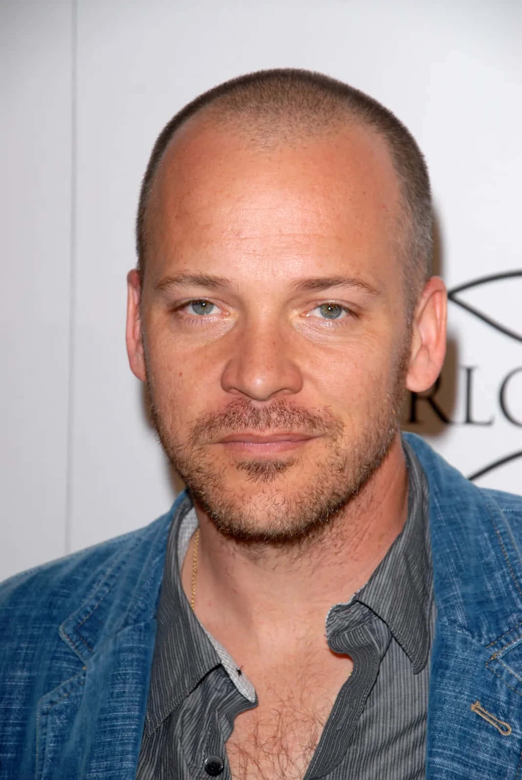 Peter Sarsgaard 桌布 壁紙 — 一名短髮、鬍渣的男子穿著牛仔外套配搭條紋襯衫的特寫肖像。