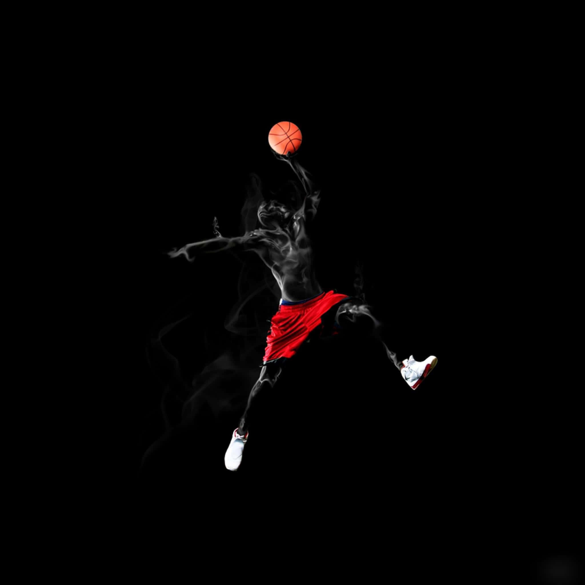 Cool Basketball 桌布 壁紙 — 一名穿著紅色短褲的籃球運動員在黑色背景上跳躍，帶有煙霧效果，手持橙色球。