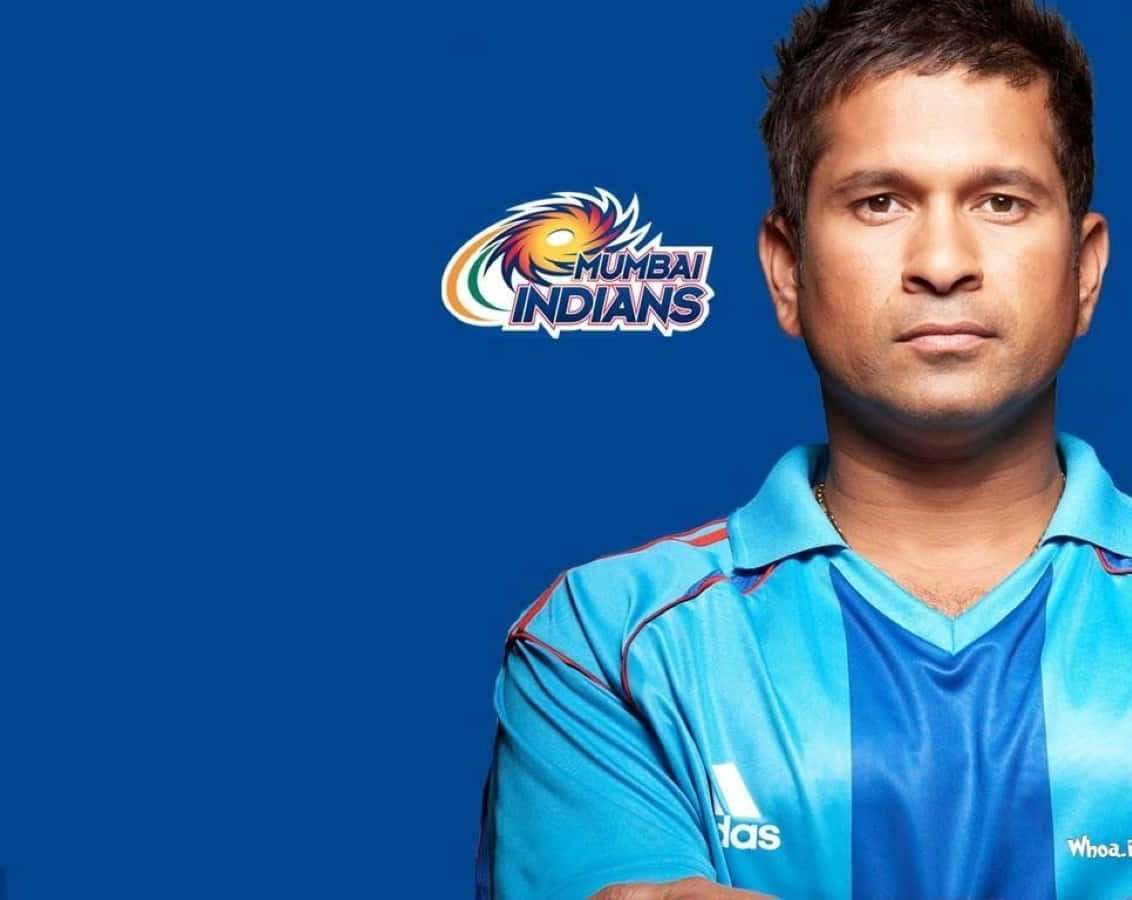 Sachin Tendulkar 桌布 壁紙 — 一名穿著藍色Mumbai Indians球衣的板球運動員在純藍色背景前與球隊標誌合影。