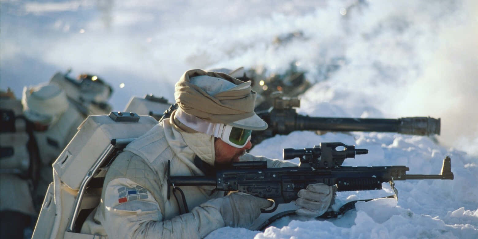 Blaster Rifles 桌布 壁紙 — 一名穿著雪地裝備的士兵在雪地戰場上以俯臥姿勢瞄準步槍，附近有裝甲車輛。