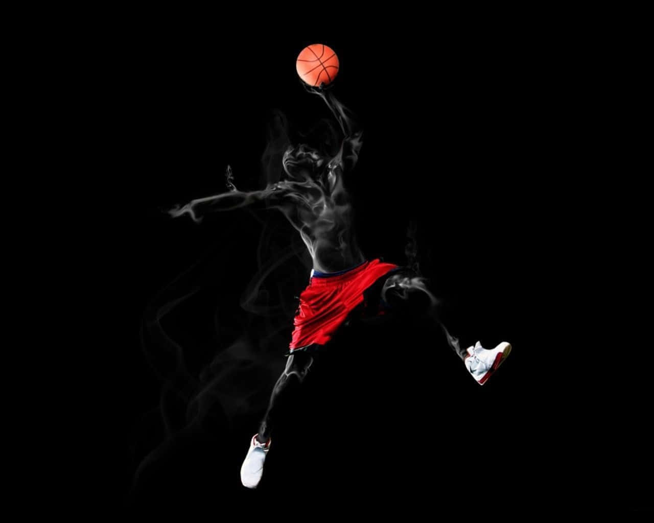 佐敦 桌布 壁紙 — 一名籃球運動員在半空中，伴隨著煙霧效果，手持橙色球，背景為黑色。