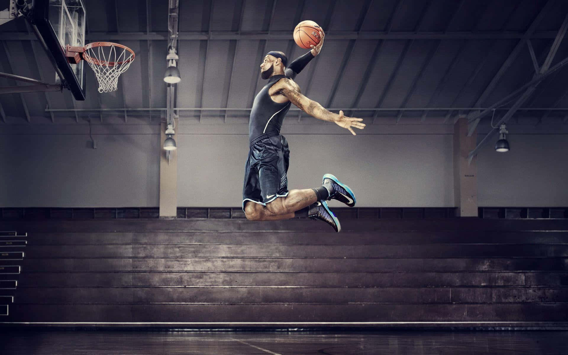 Cool Basketball 桌布 壁紙 — 一名籃球運動員在室內體育館高高躍起，準備以高度專注力灌籃。