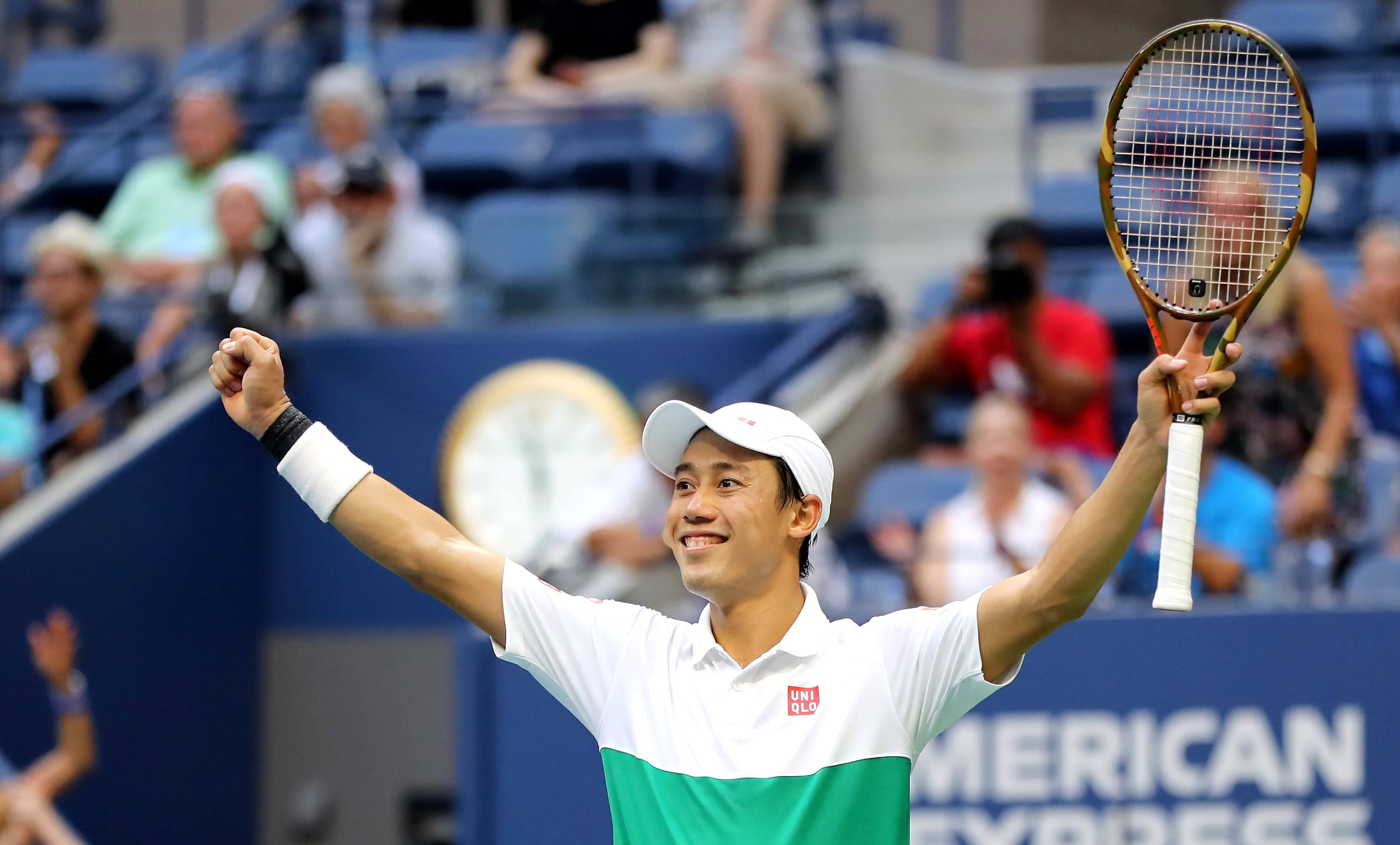 一名網球選手在球場上慶祝勝利 壁紙 — 一位微笑的網球選手在陽光普照的球場上舉起拳頭和球拍慶祝勝利。