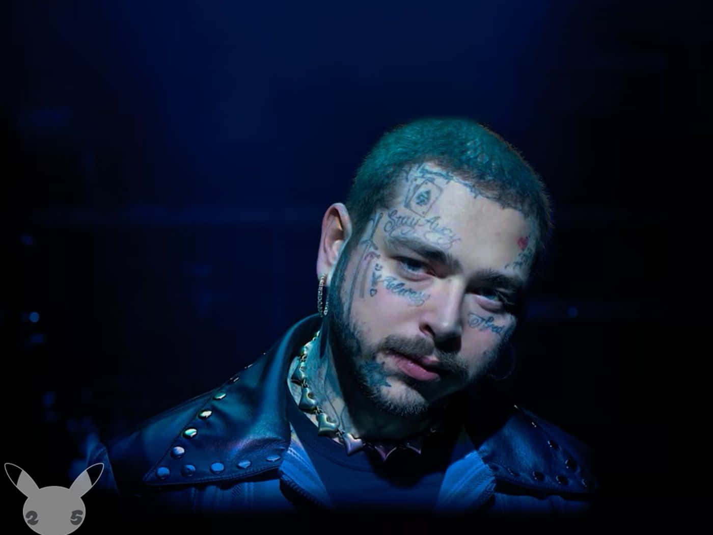 Post Malone 桌布 壁紙 — 一名臉上和頸部有紋身的男子，在藍色舞台燈光下穿著帶有鉚釘的皮褸。