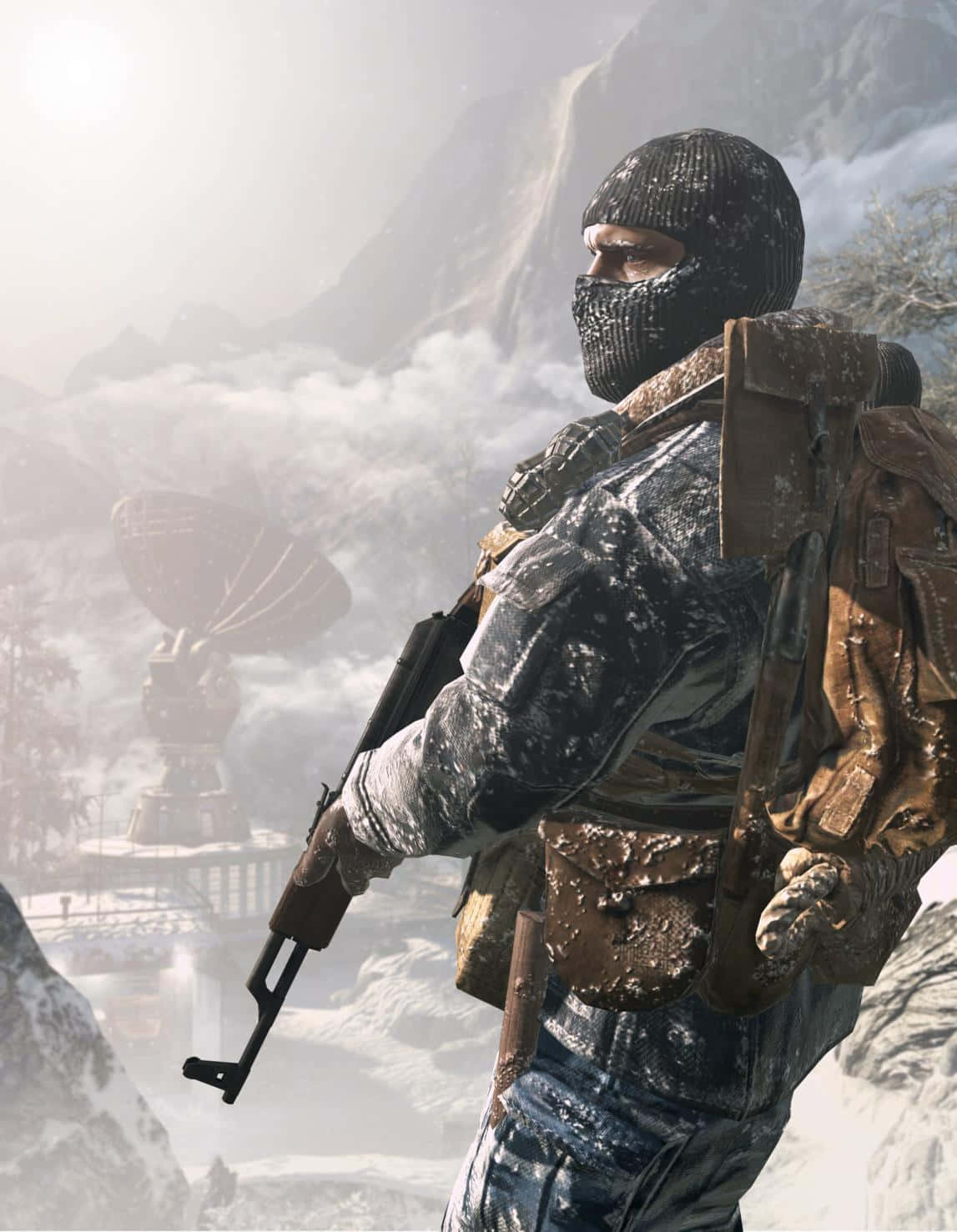 Call Of Duty Soldiers 桌布 壁紙 — 一名被雪覆蓋的士兵戴著巴拉克拉瓦帽和裝備，站在多山的冬季景觀中，在衛星天線附近拿著步槍。