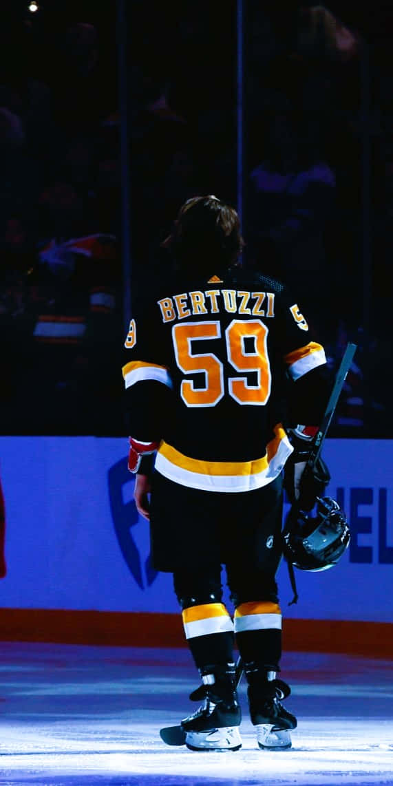 Tyler Bertuzzi 桌布 壁紙 — 一名身穿59號球衣的冰球運動員獨自站在冰場上，手持球棍和頭盔。