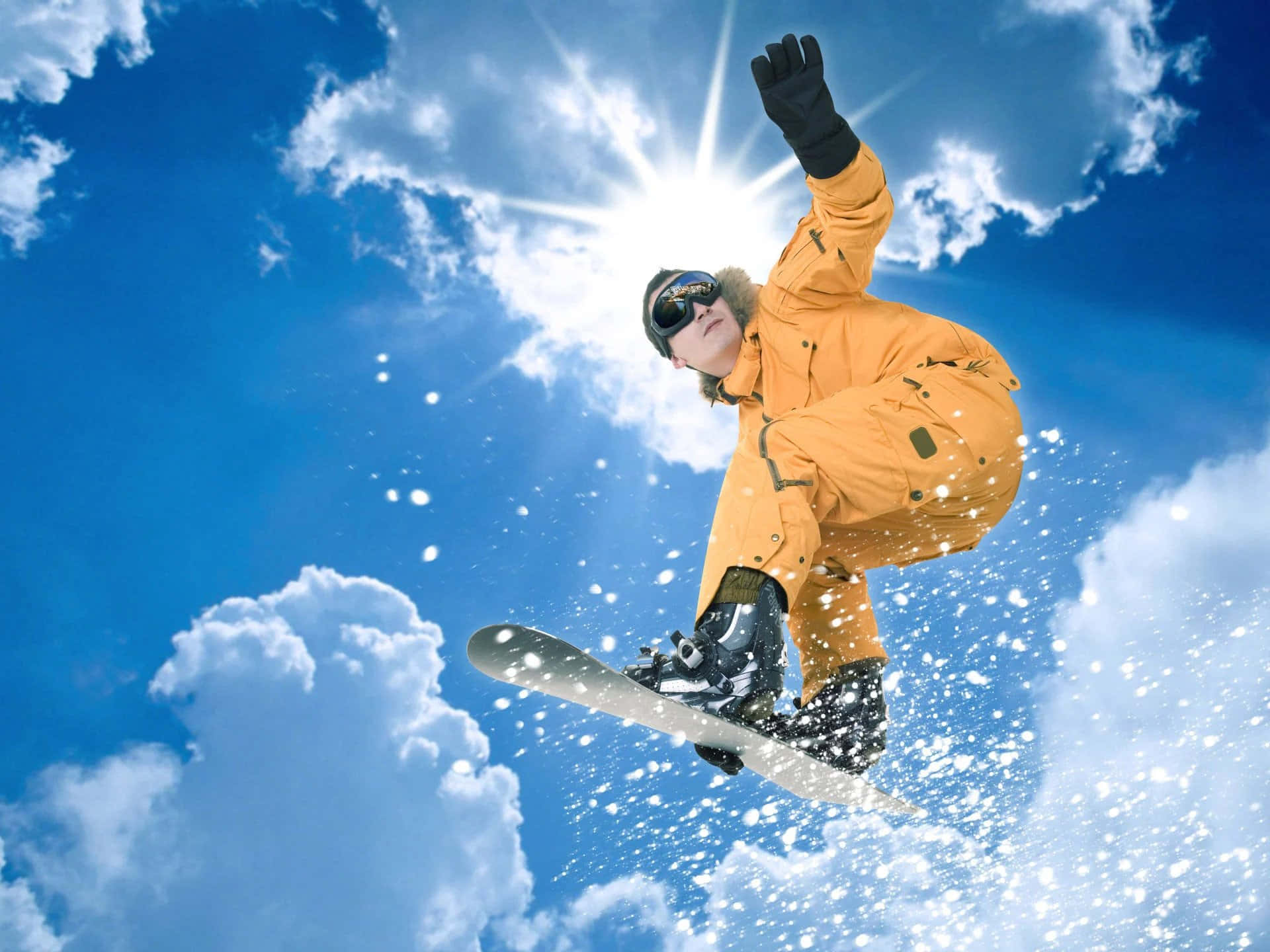 Skiing 桌布 壁紙 — 一名身穿亮橙色套裝的滑雪板運動員在藍天白雲和陽光四射的背景下騰空飛翔。