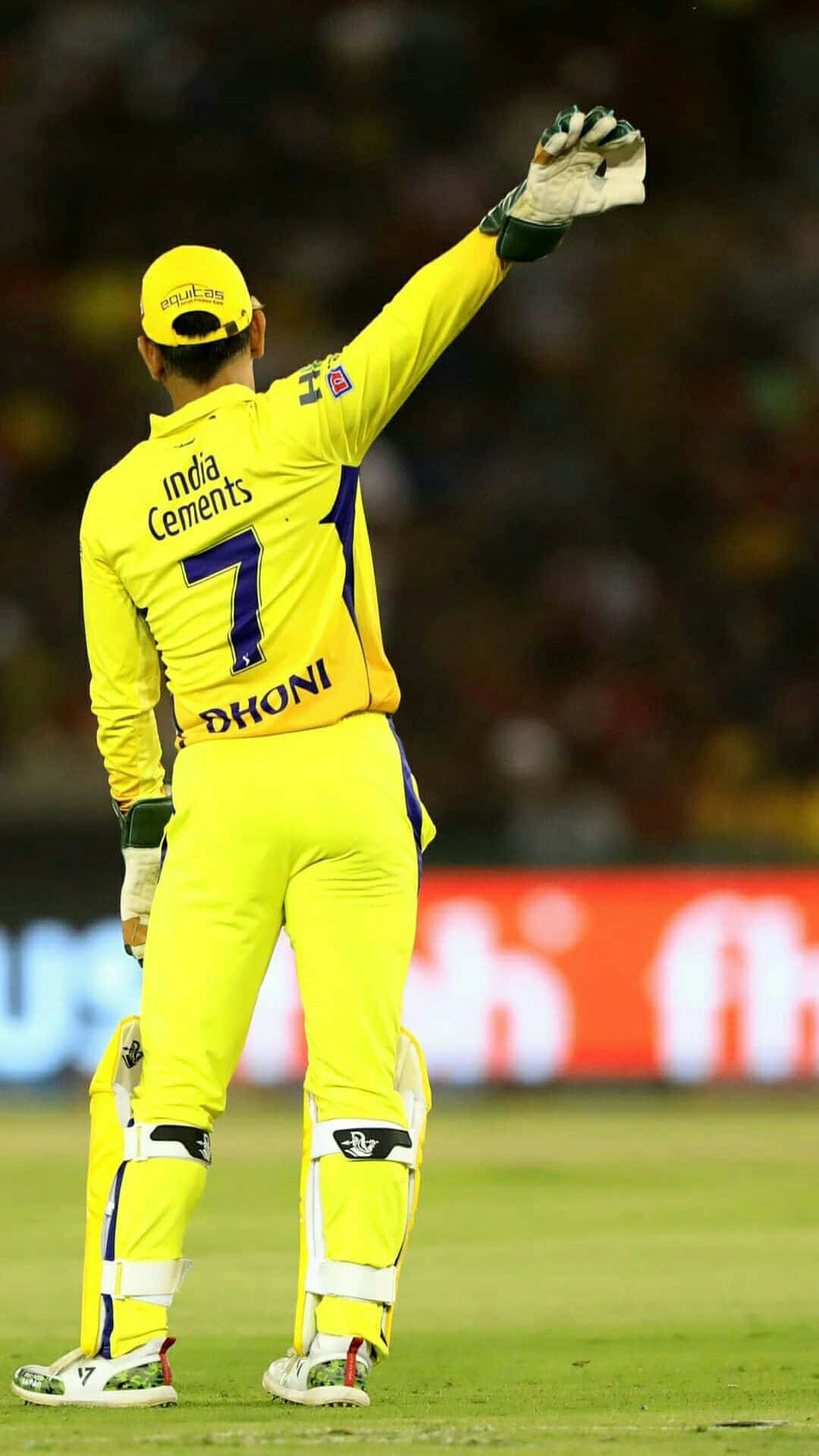Cricket 桌布 壁紙 — 一名身穿亮黃色球衣的板球運動員在夜間球場上向球迷揮手。
