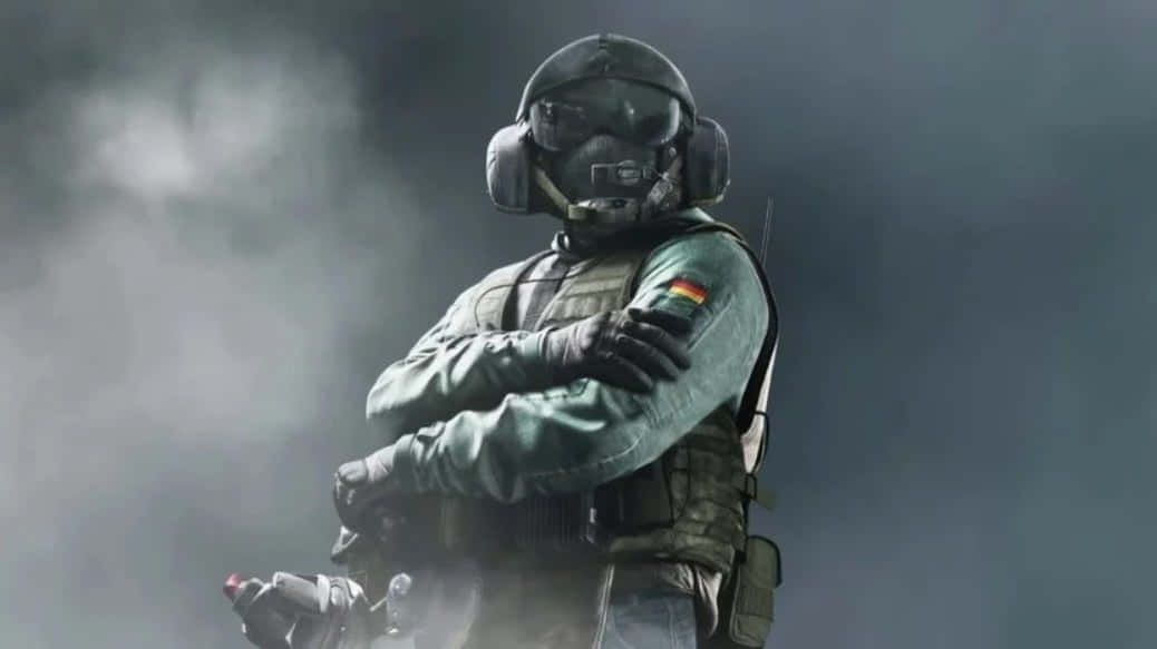 Rainbow Six Siege Jager 桌布 壁紙 — 一名身穿全套戰術裝備的士兵，在煙霧彌漫的灰色背景下，雙臂交叉，堅定地站立。
