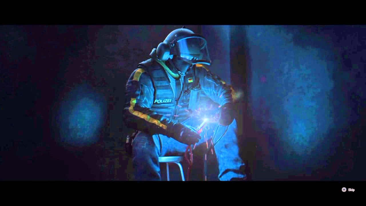 Rainbow Six Siege Bandit 桌布 壁紙 — 一名身穿全套裝備的警方炸彈處理專家，在昏暗的藍色照明環境中小心處理一個發光裝置。
