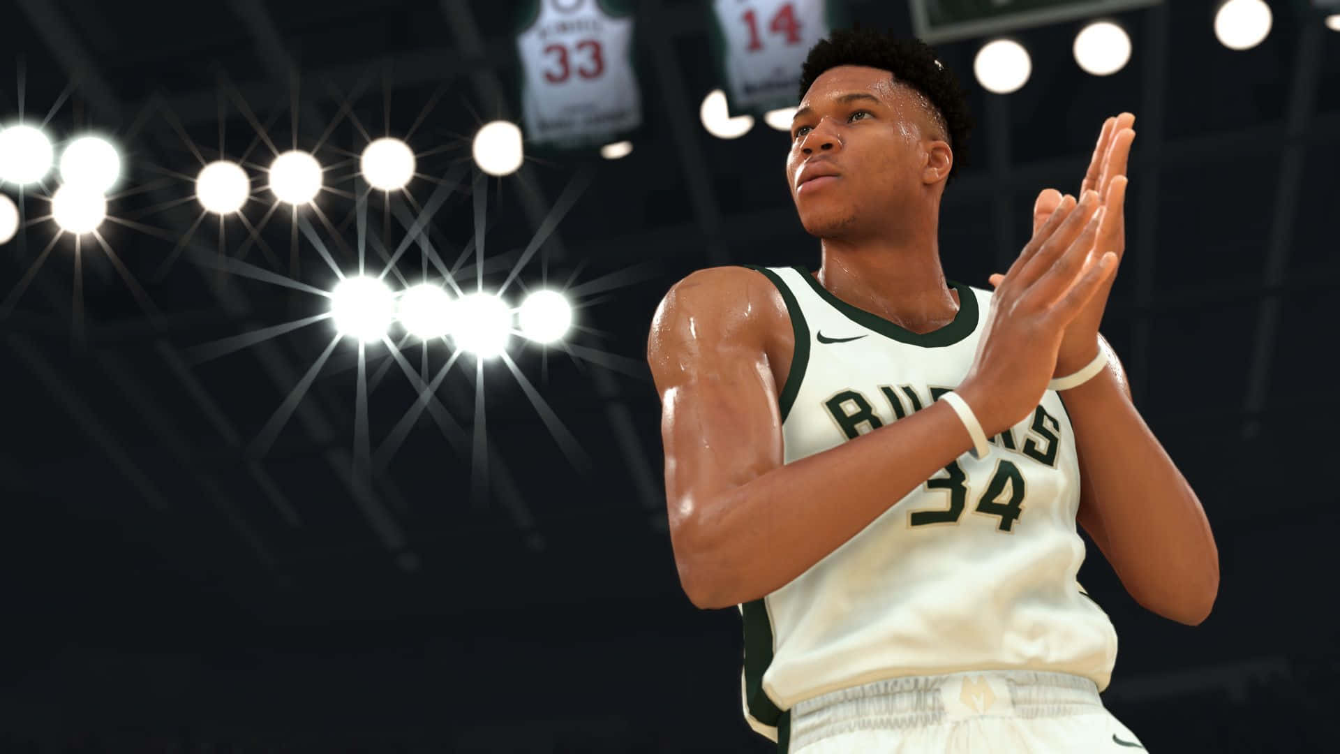 NBA 2k20 桌布 壁紙 — 一名身穿密爾沃基公鹿隊球衣的籃球運動員在比賽期間於明亮的場館燈光下鼓掌。