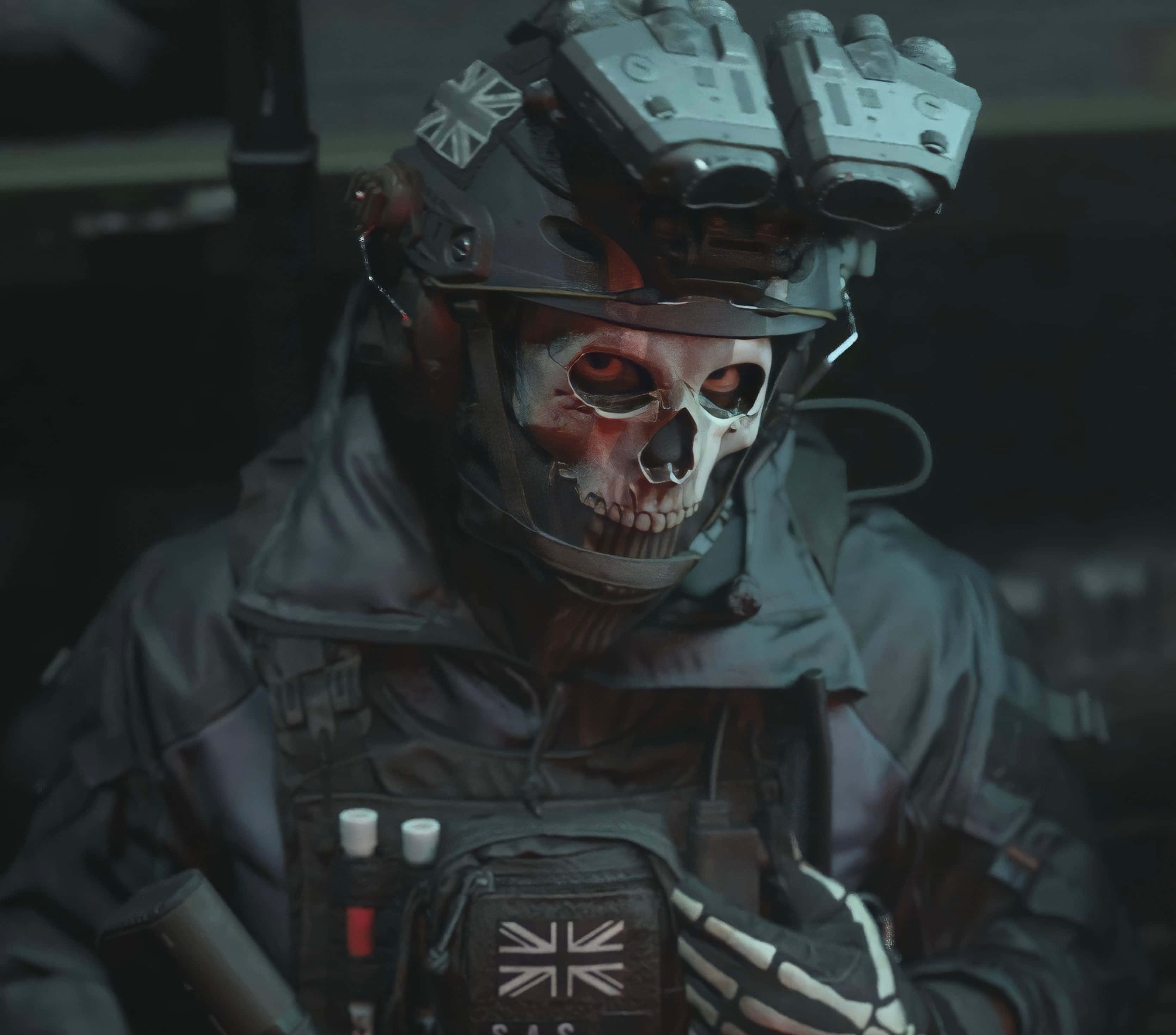Simon Ghost Riley 桌布 壁紙 — 一名身穿戰術裝備、戴著骷髏面具和英國國旗徽章的士兵，在昏暗的環境中凝視著。