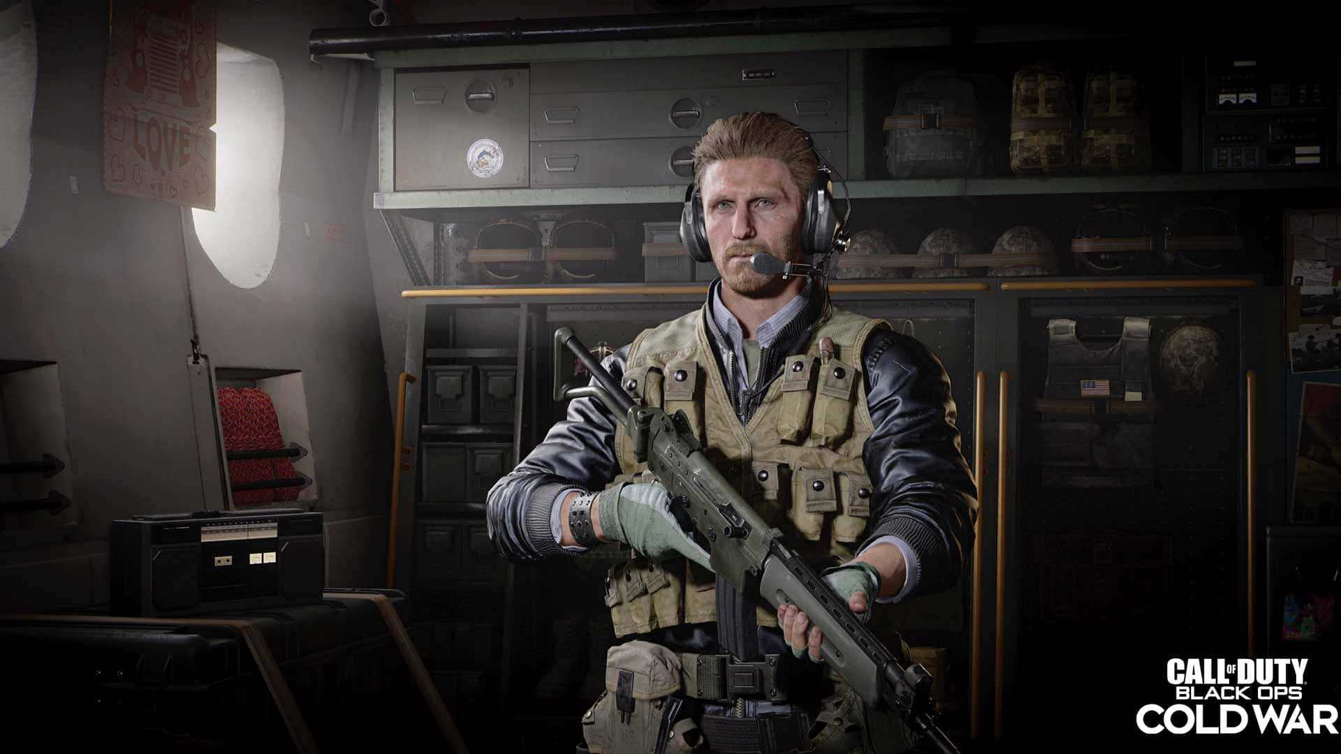 Call Of Duty Black Ops Cold War 桌布 壁紙 — 一名身穿戰術裝備的士兵在光線昏暗的軍用飛機庫內手持步槍，身後有設備架。