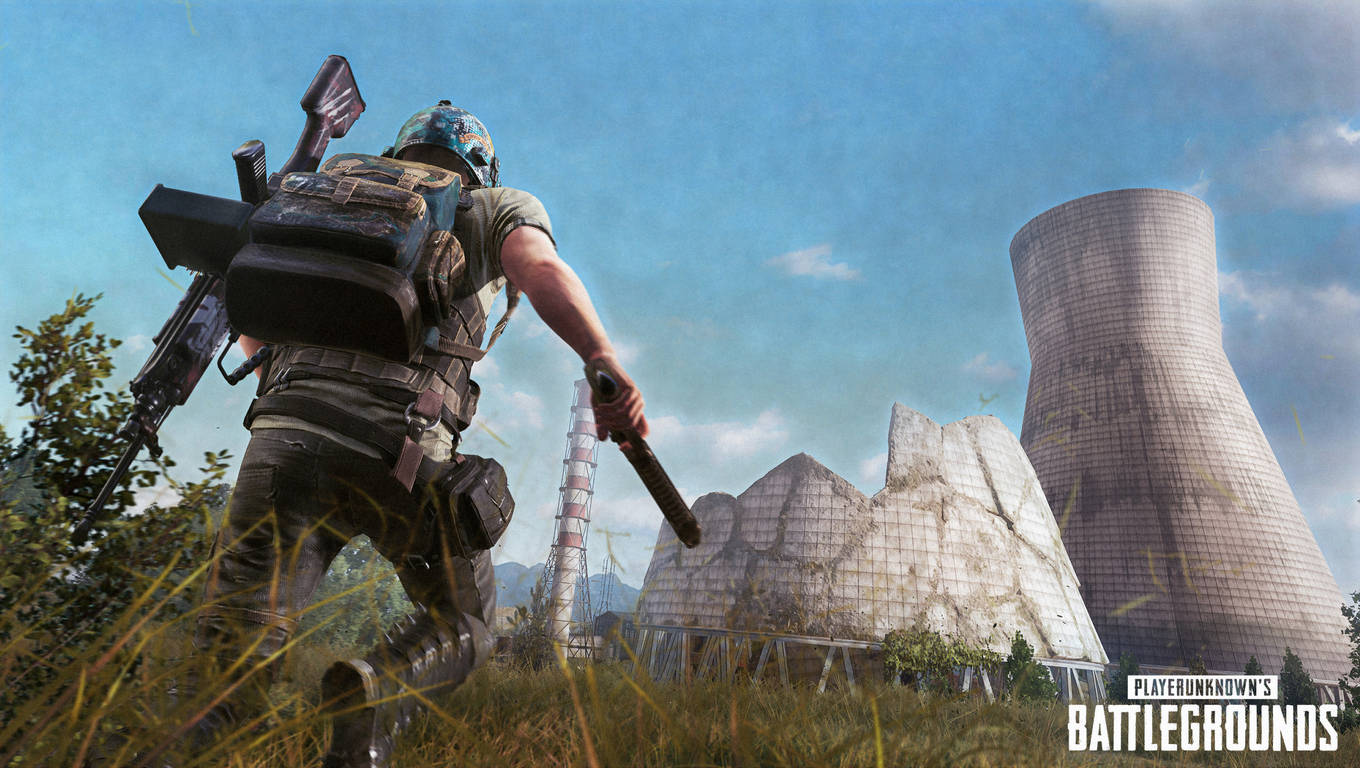 pubg mobile 桌布 壁紙 — 一名身穿戰術裝備的士兵穿過高草叢，奔向一座在明亮藍天下被毀的核電廠。