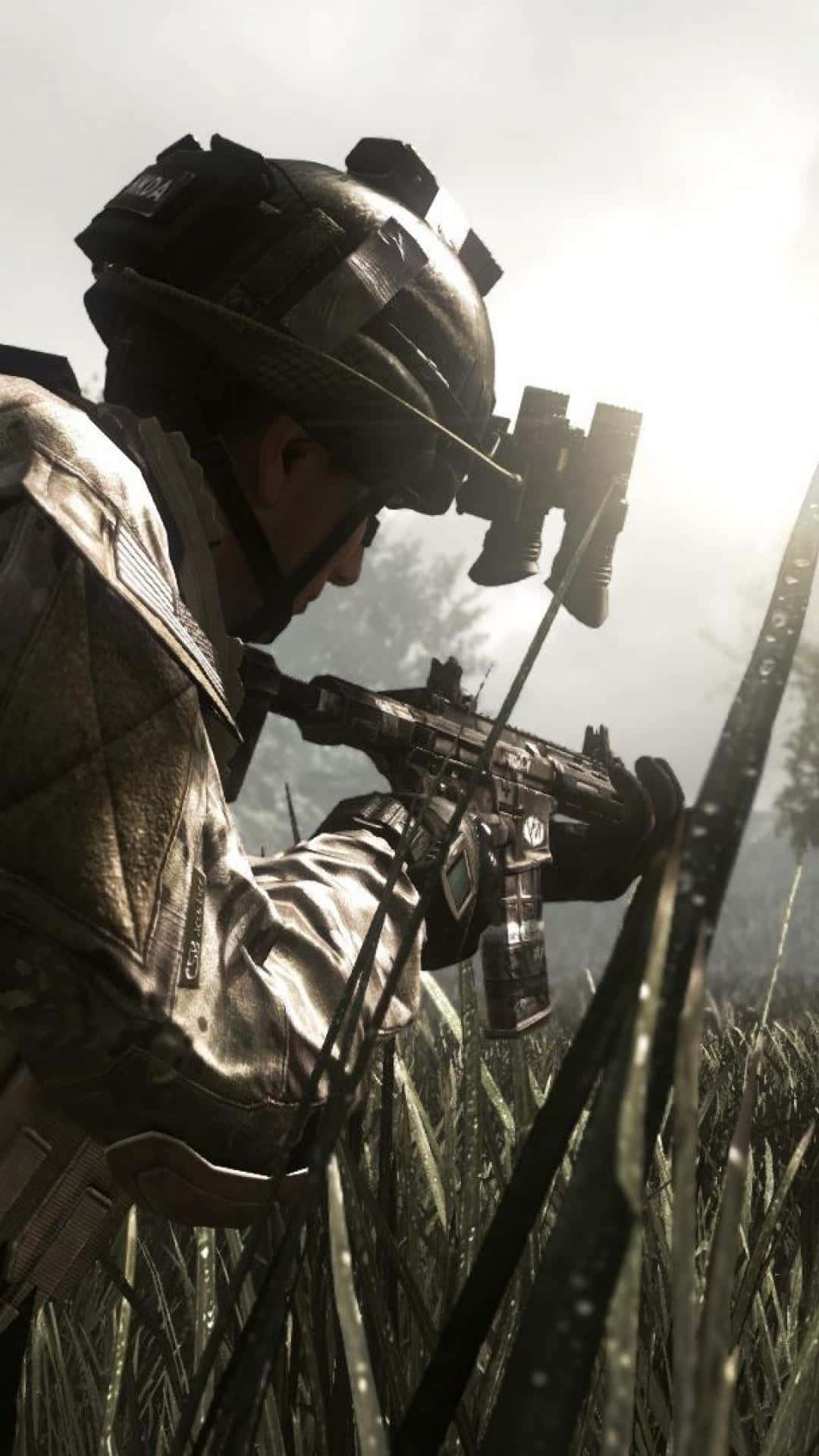 Call Of Duty Mobile 桌布 壁紙 — 一名身穿戰術裝備的士兵蹲在高草叢中，在明亮的天空下持步槍。