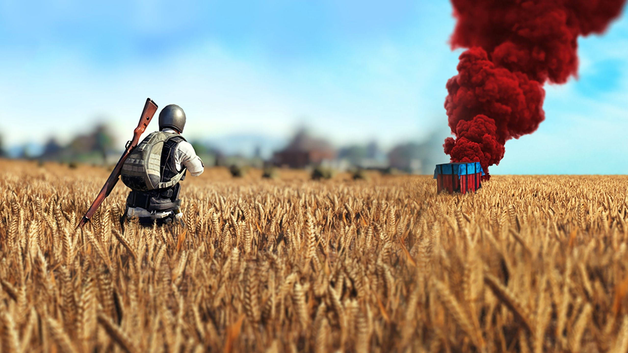 Playerunknown's Battlegrounds 桌布 壁紙 — 一名身穿戰鬥裝備的士兵走過金色麥田，走向遠處從板條箱升起的紅色煙霧。