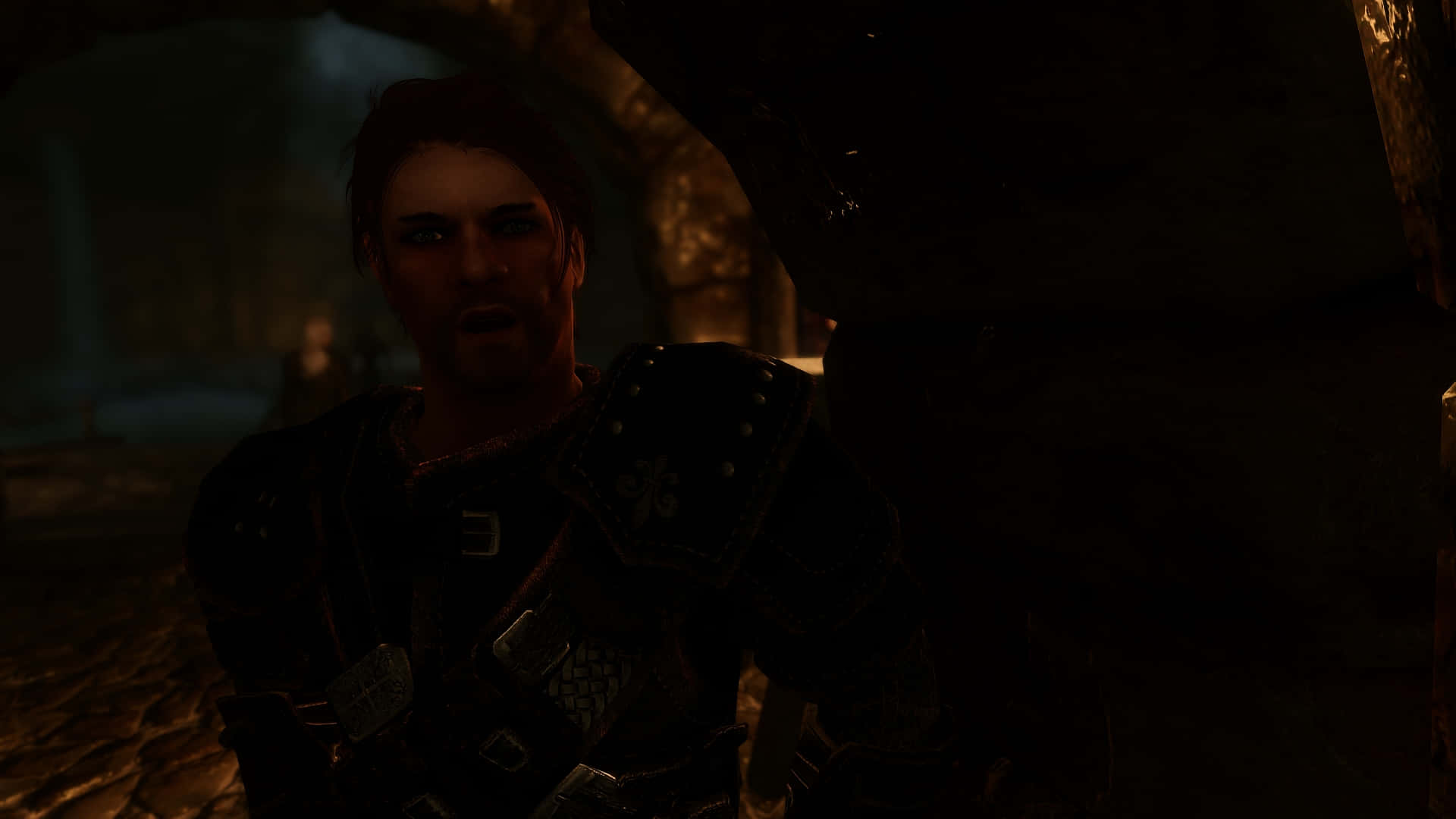 Skyrim Brynjolf 桌布 壁紙 — 一名身穿暗色盔甲的戰士在石造地牢的昏暗火炬光下震驚地凝視。