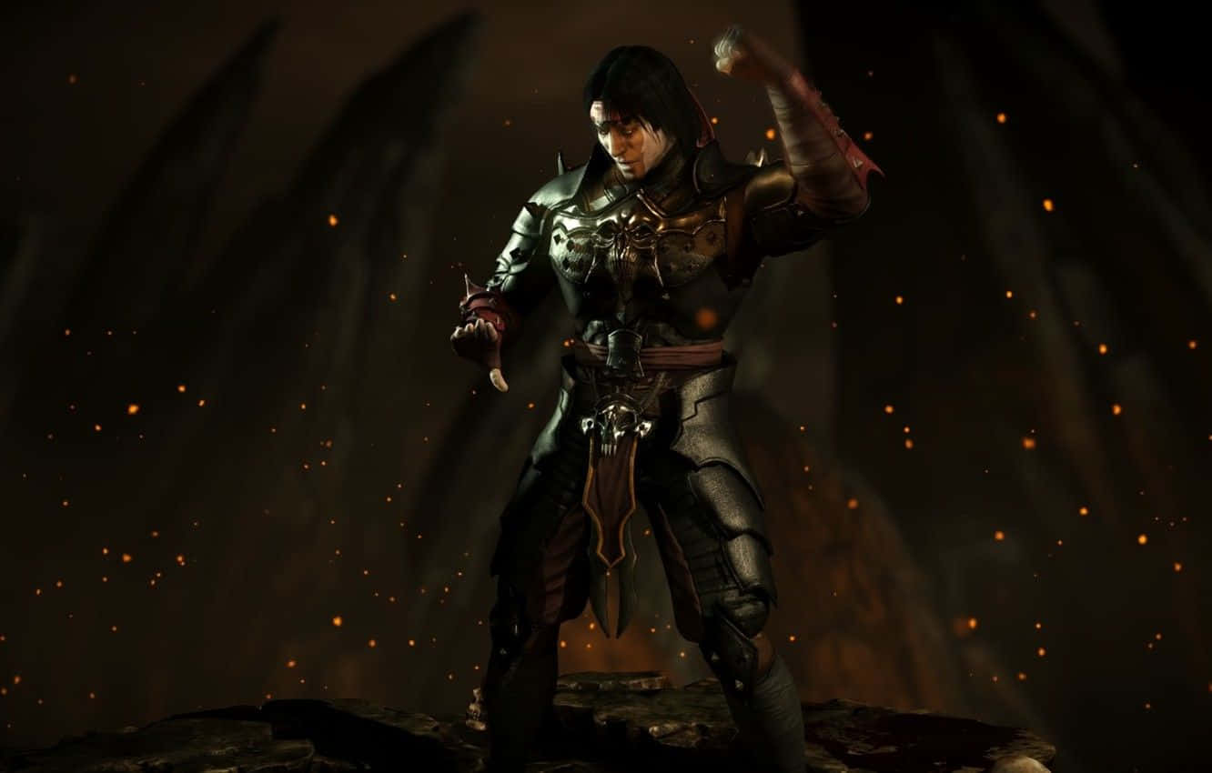 Mortal Kombat Liu Kang 桌布 壁紙 — 一名身穿暗色鎧甲的戰士站在岩石地面上，陰暗洞穴般的空間中漂浮著發光的餘燼。