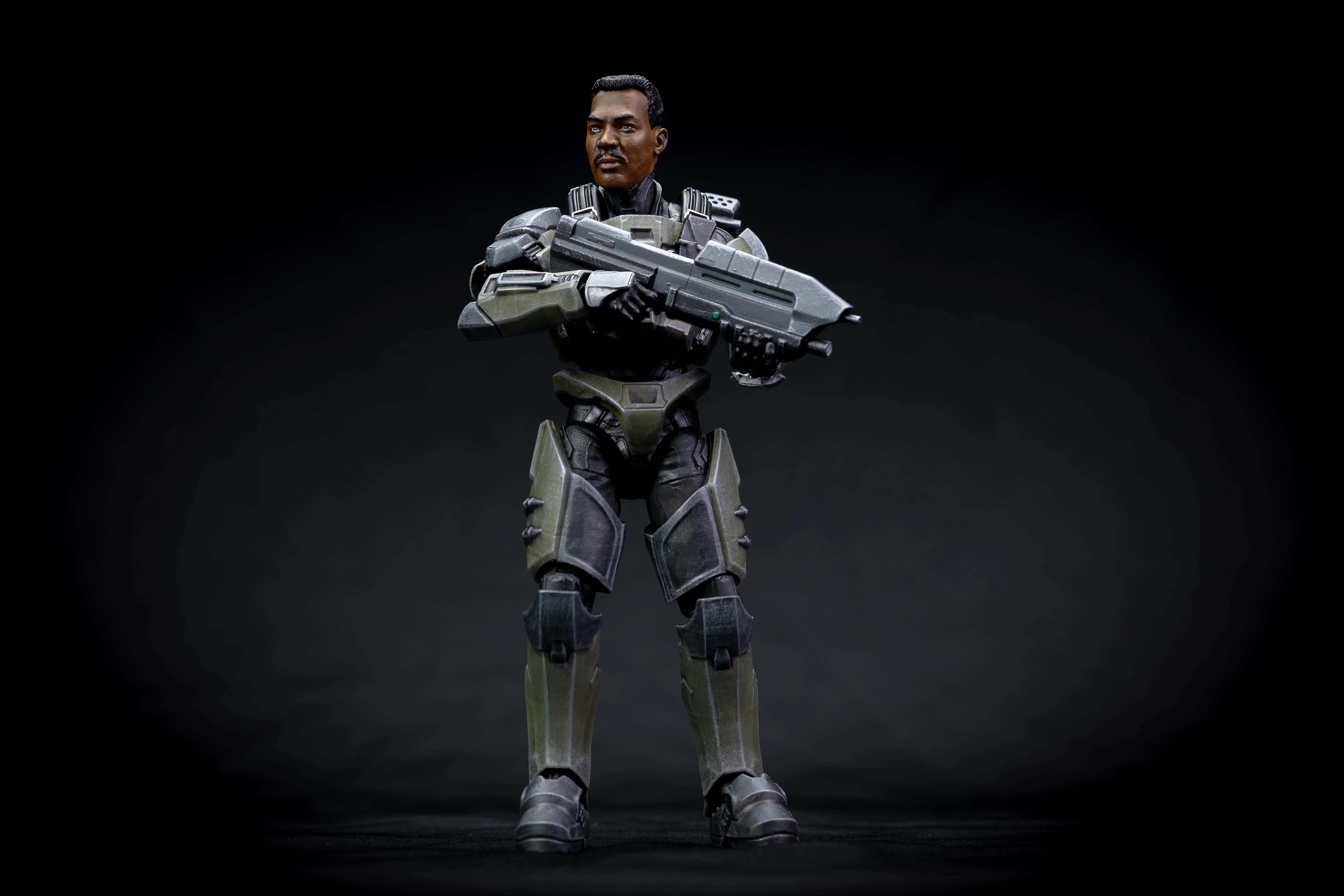 Sergeant Johnson 桌布 壁紙 — 一名身穿未來裝甲的士兵，在深色漸變背景前手持大型武器，蓄勢待發。