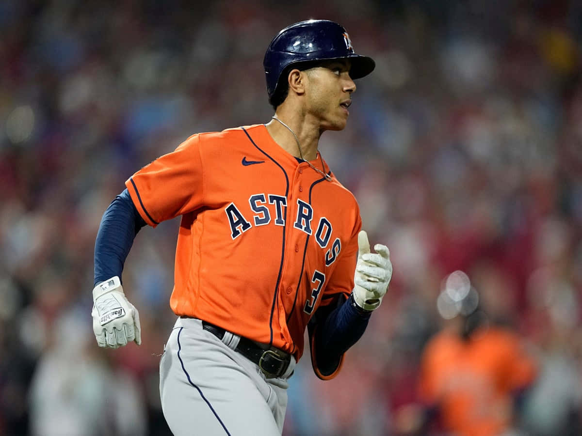 Astros 桌布 壁紙 — 一名身穿橙色球衣的侯斯頓太空人棒球選手在球場燈光下的夜間比賽中專注地衝刺。