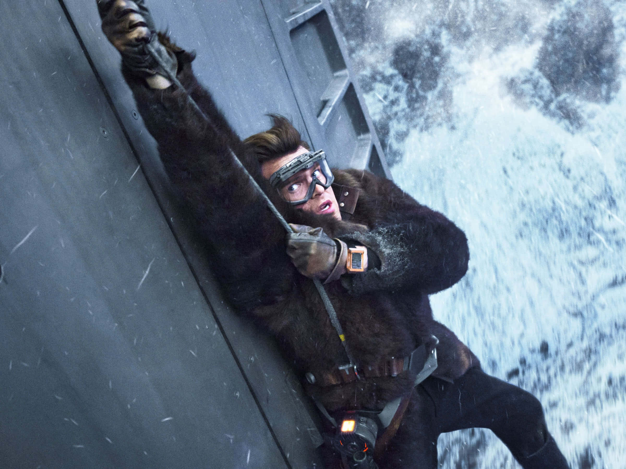 Solo A Star Wars Story 桌布 壁紙 — 一名身穿毛皮大衣和護目鏡的男子在危險的攀爬中，緊緊抓住金屬牆壁，冰雪呼嘯而過。