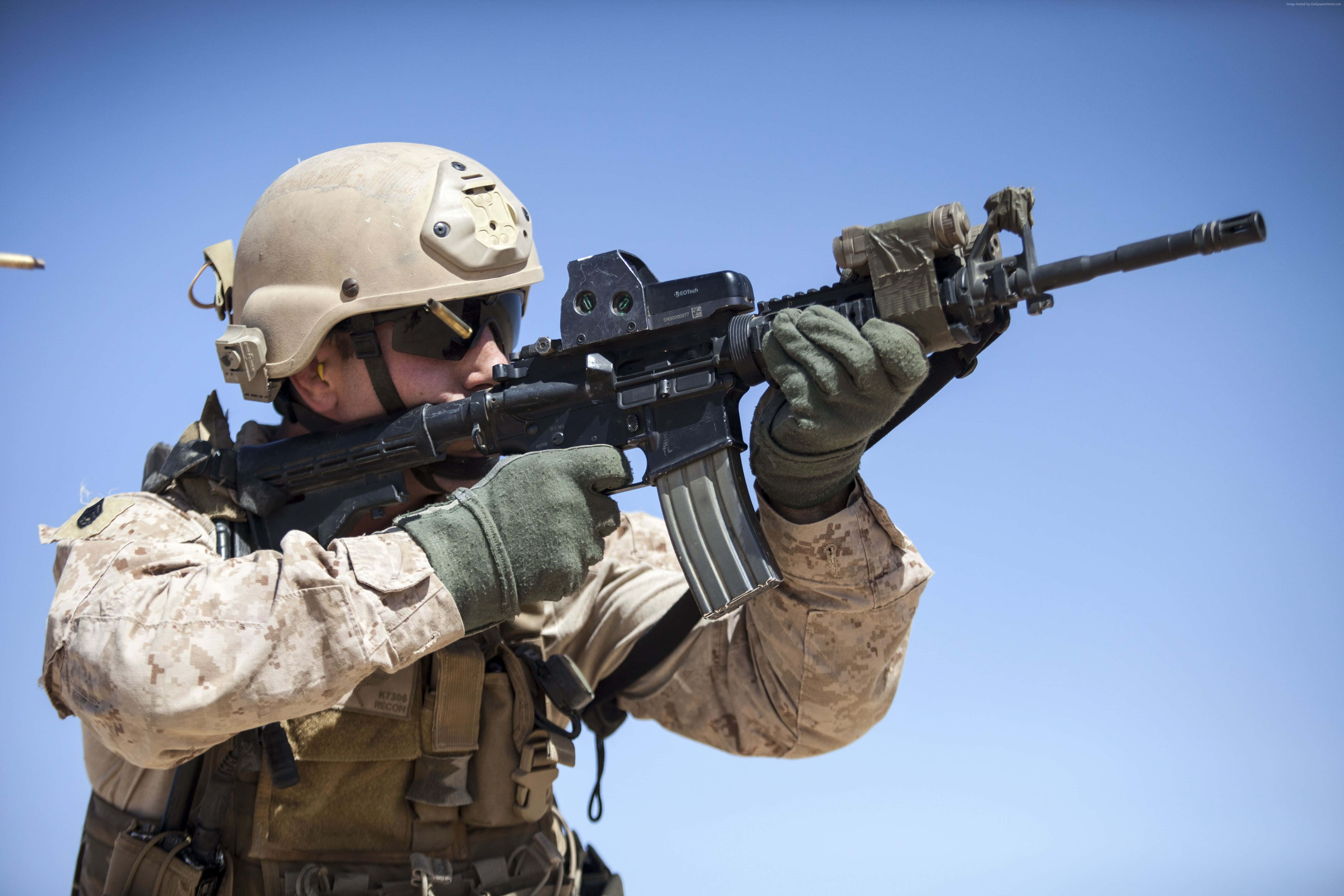 Army 桌布 壁紙 — 一名身穿沙漠迷彩的士兵在晴朗的藍天下瞄準步槍，一顆用過的彈殼飛過。